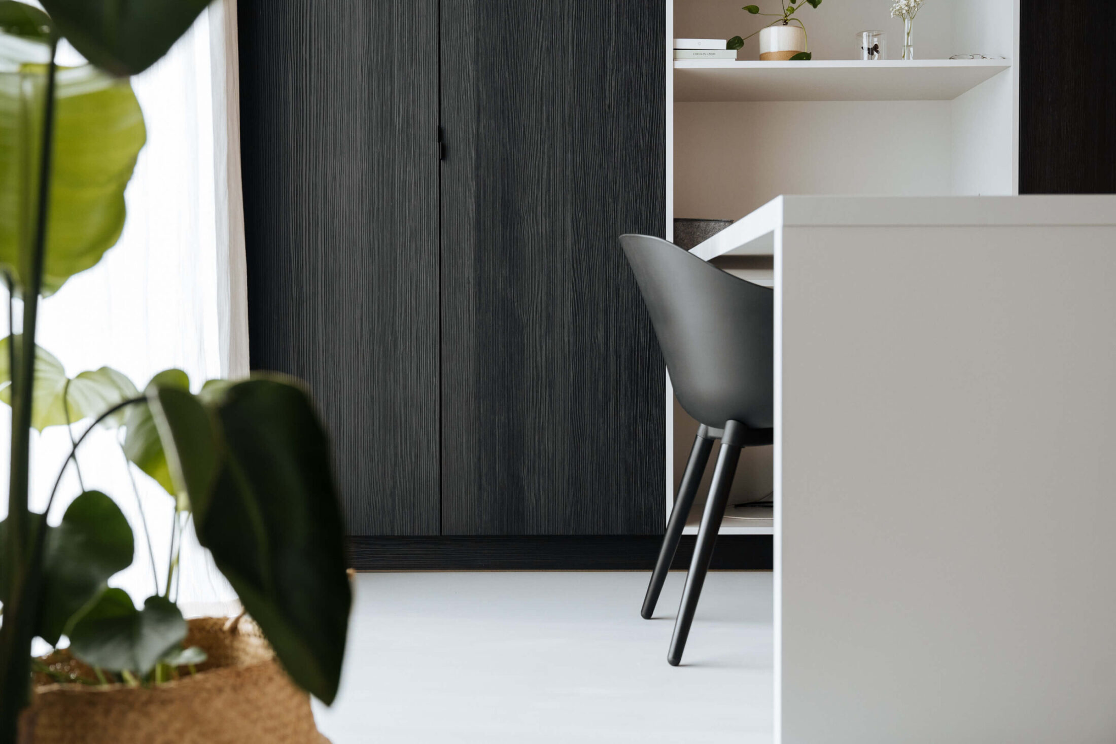 Detail van een industriële keuken met donkere houten kastenwand en wit werkblad in Kortrijk, Kaster Keukens