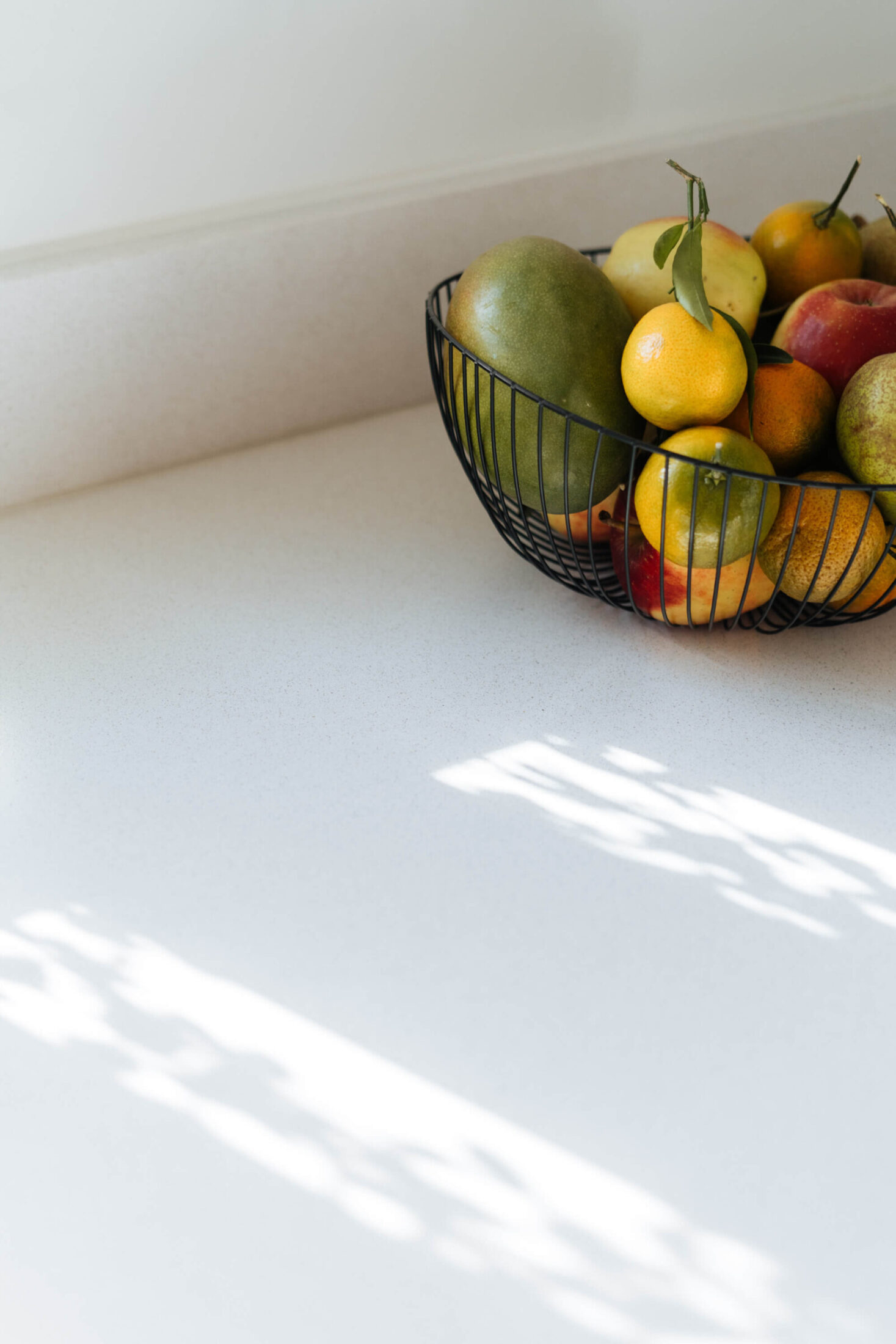 Detail van een landelijke keuken met fruitschaal op een wit werkblad in Aalter, Kaster Keukens