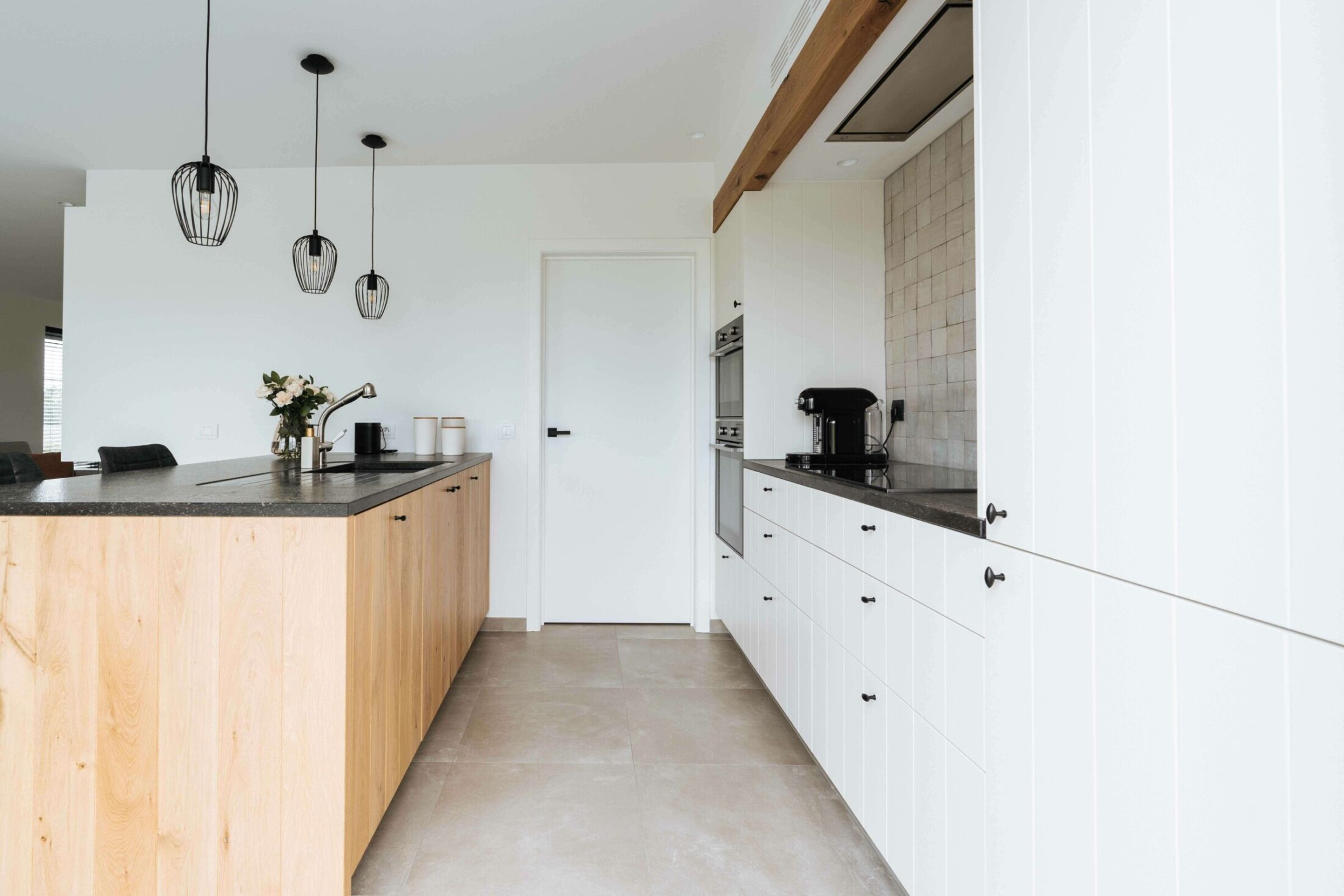 Landelijke keuken met eiken eiland, witte kastenwand en donker werkblad in Dadizele, Kaster Keukens