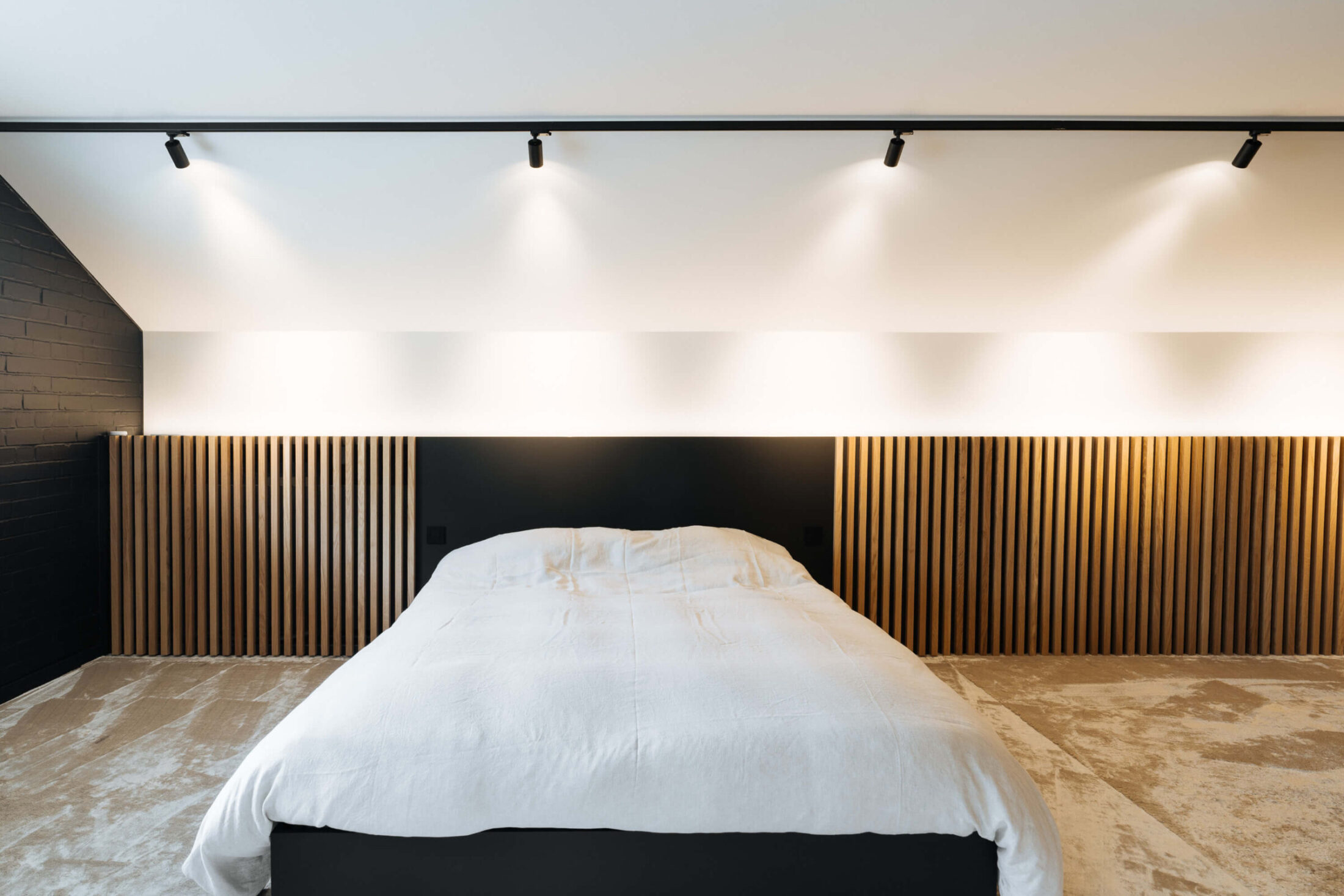 Bedwand op maat met eiken lamellen en zwart hoofdbord in Roeselare, Kaster Keukens