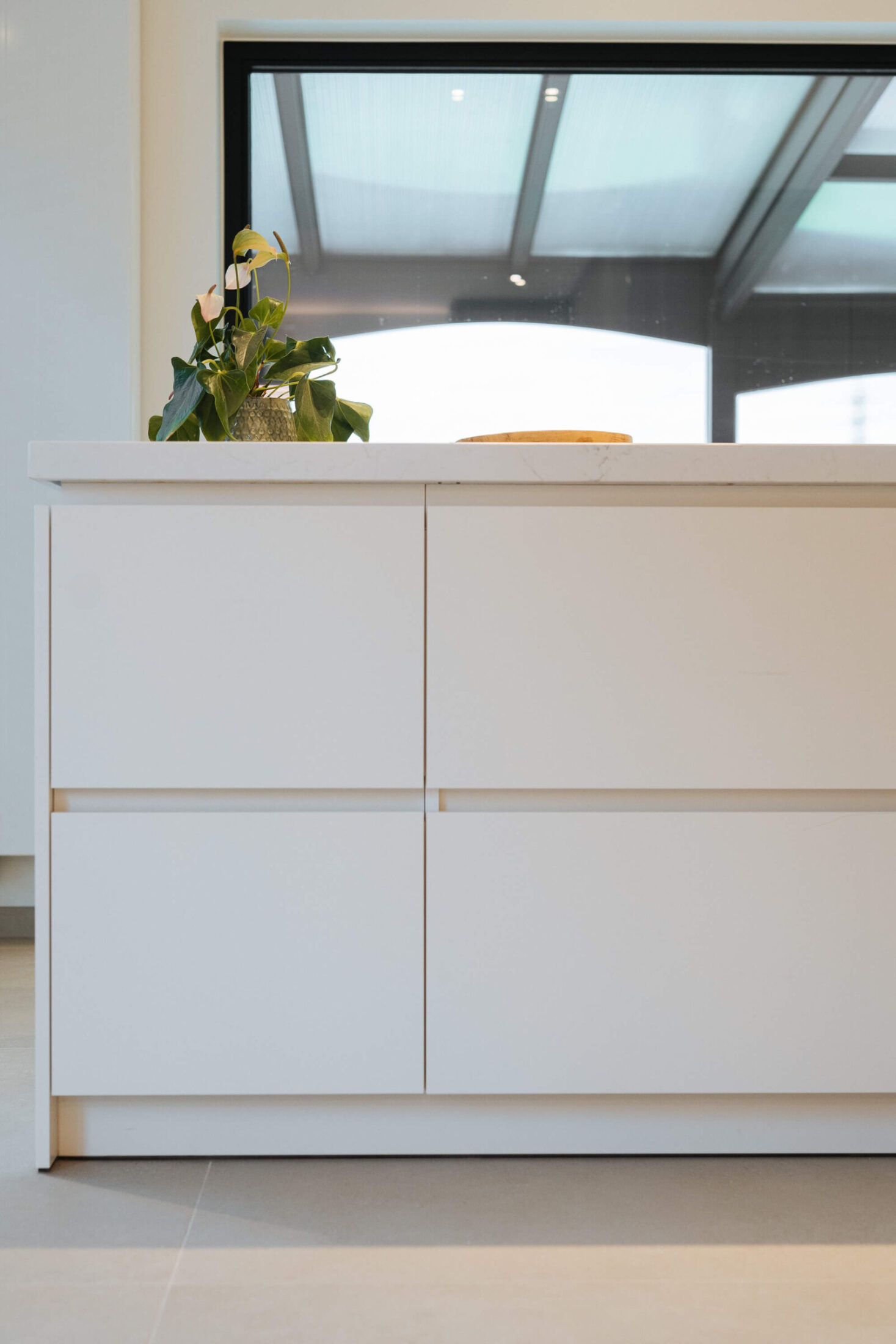 Detail van een moderne keuken met witte greeploze lades in het eiland in Bellegem, Kaster Keukens