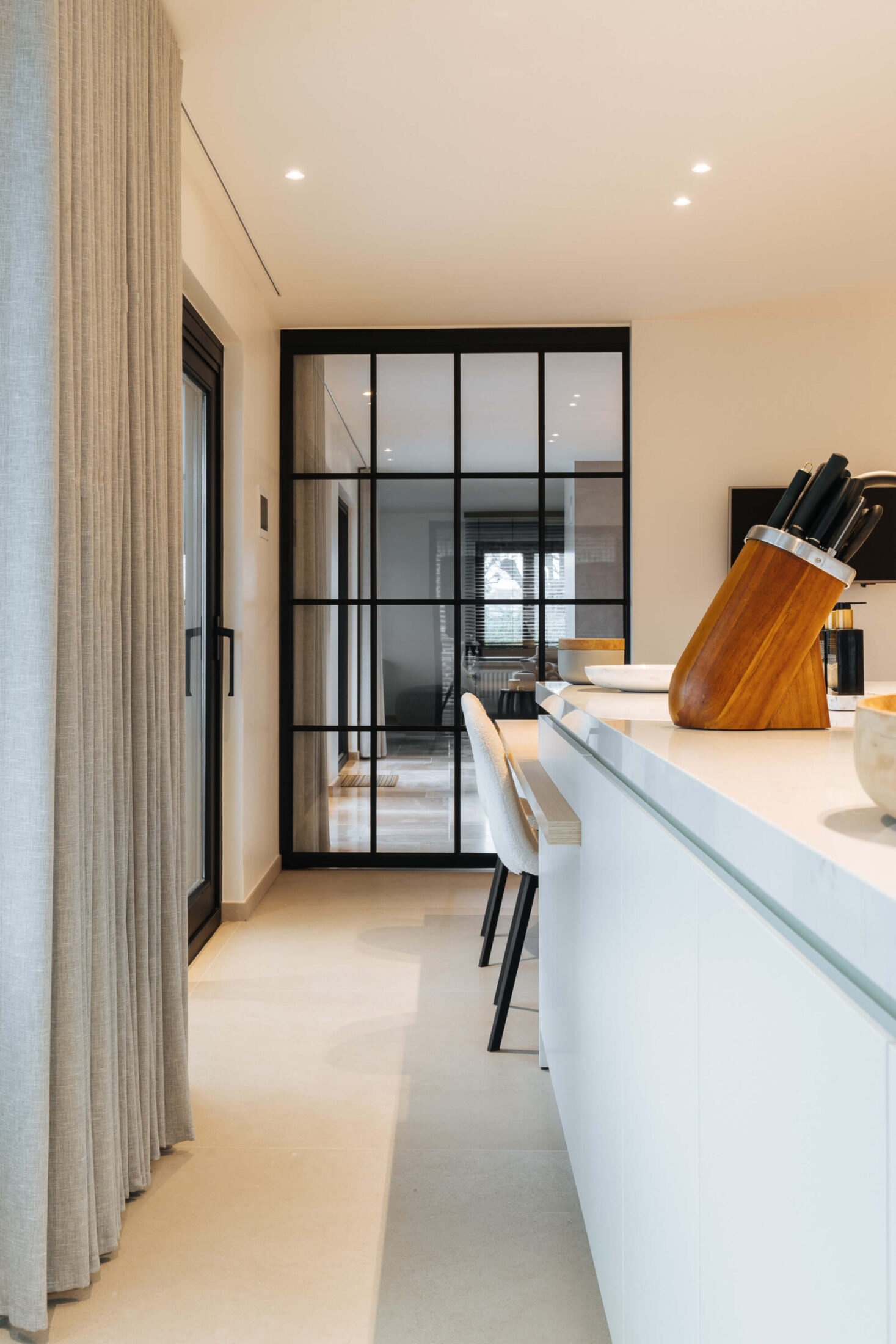 Detail van een moderne keuken met wit eiland en stalen binnendeur in Bellegem, Kaster Keukens