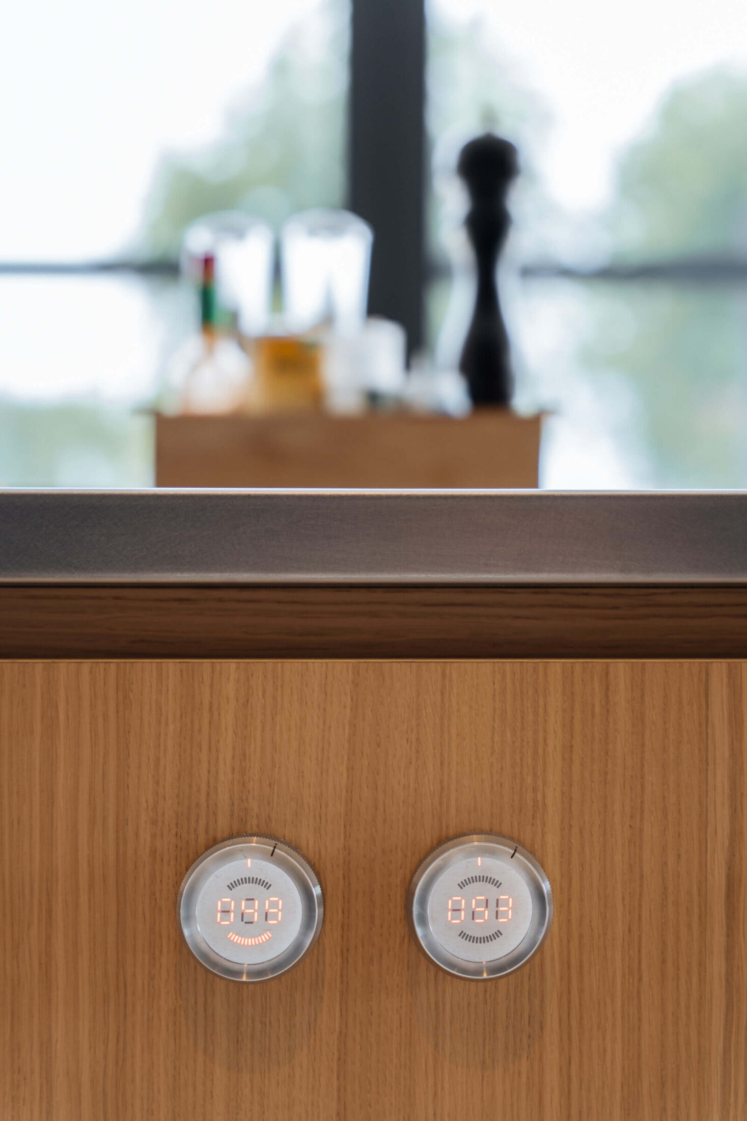 Detail van een moderne keuken met houten fronten en ingebouwde stopcontacten in Gent, Kaster Keukens