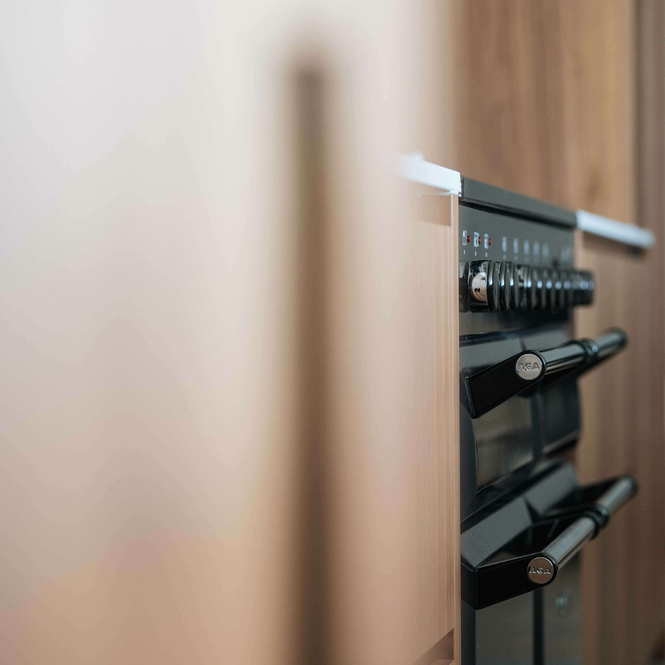 Detail van een moderne keuken met ovens in een houten hoge kast in Roeselare, Kaster Keukens