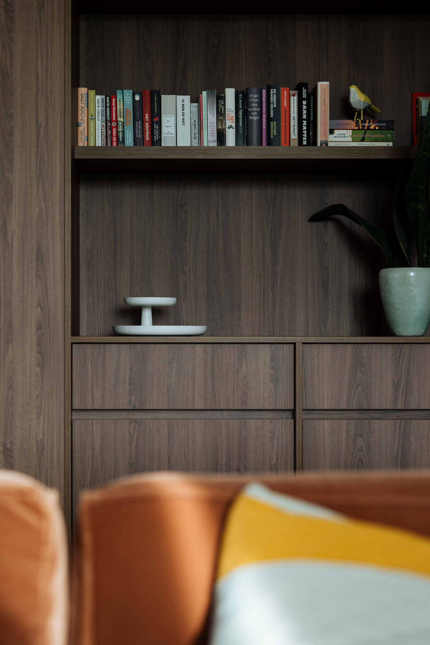 Detail van een moderne keuken met ingebouwde boekenkast in donker hout in Roeselare, Kaster Keukens