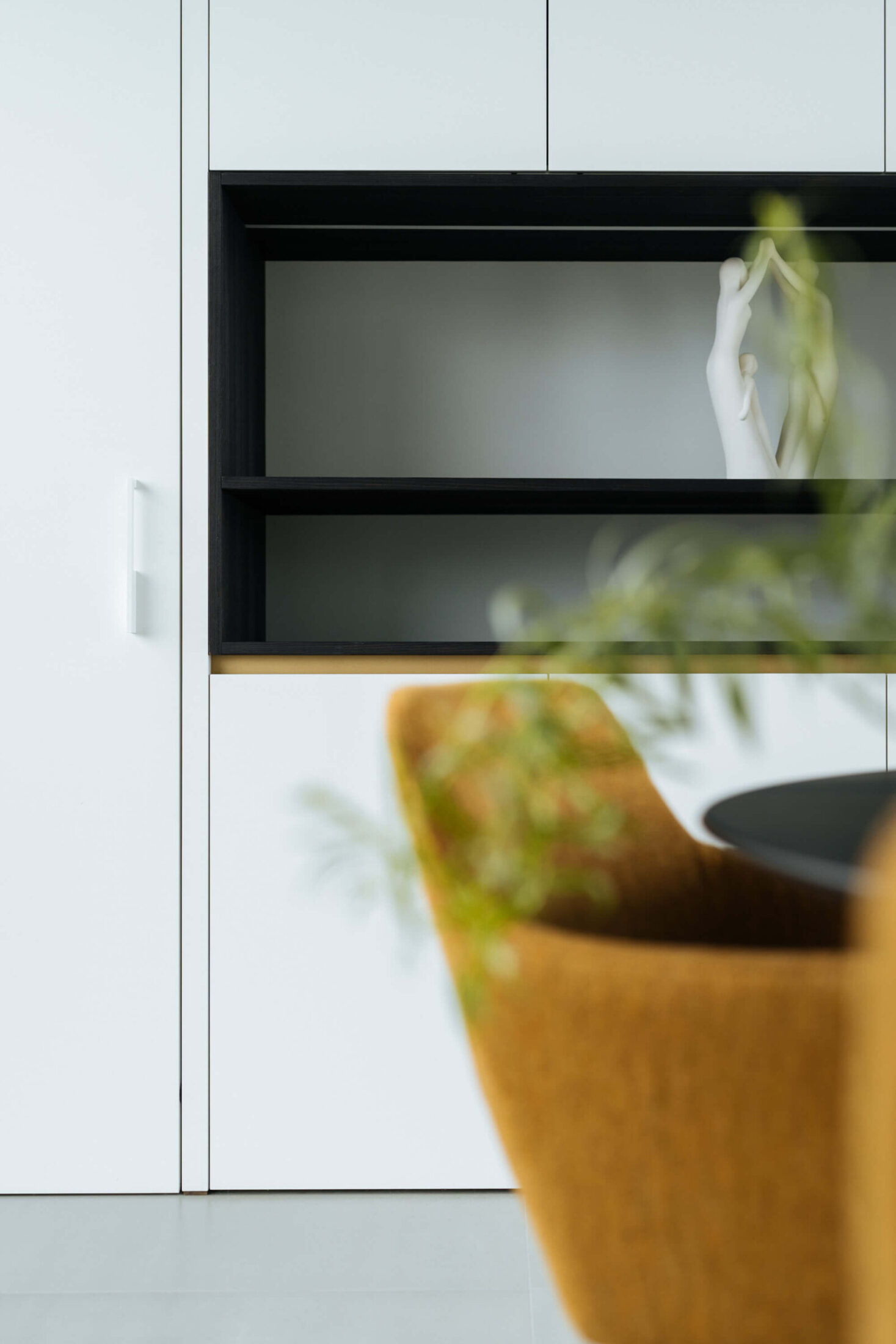 Detail van een moderne keuken met witte kasten en zwarte open nis in Wevelgem, Kaster Keukens