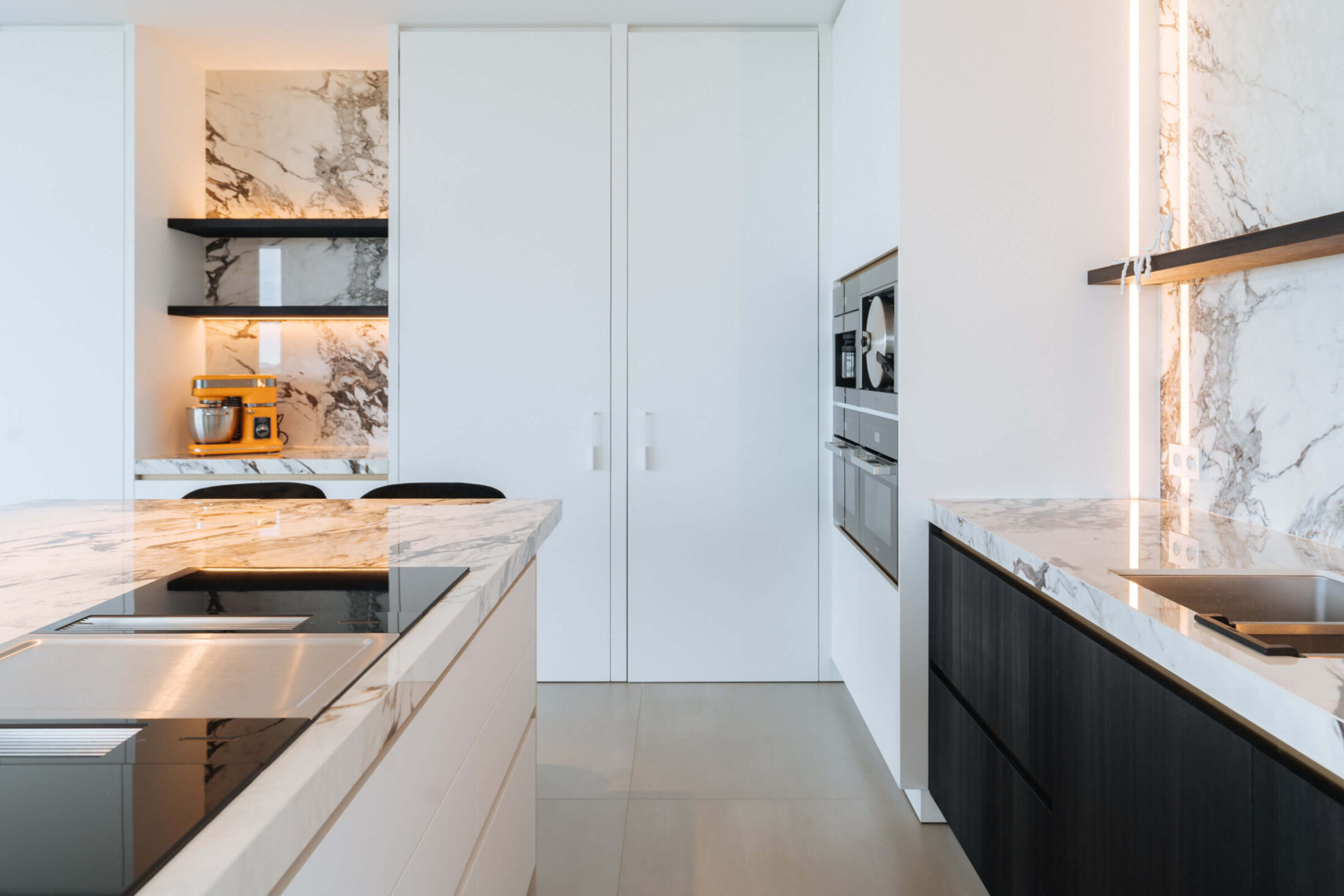 Moderne keuken met marmerlook werkblad, kookplaat en zwarte onderkasten in Wevelgem, Kaster Keukens