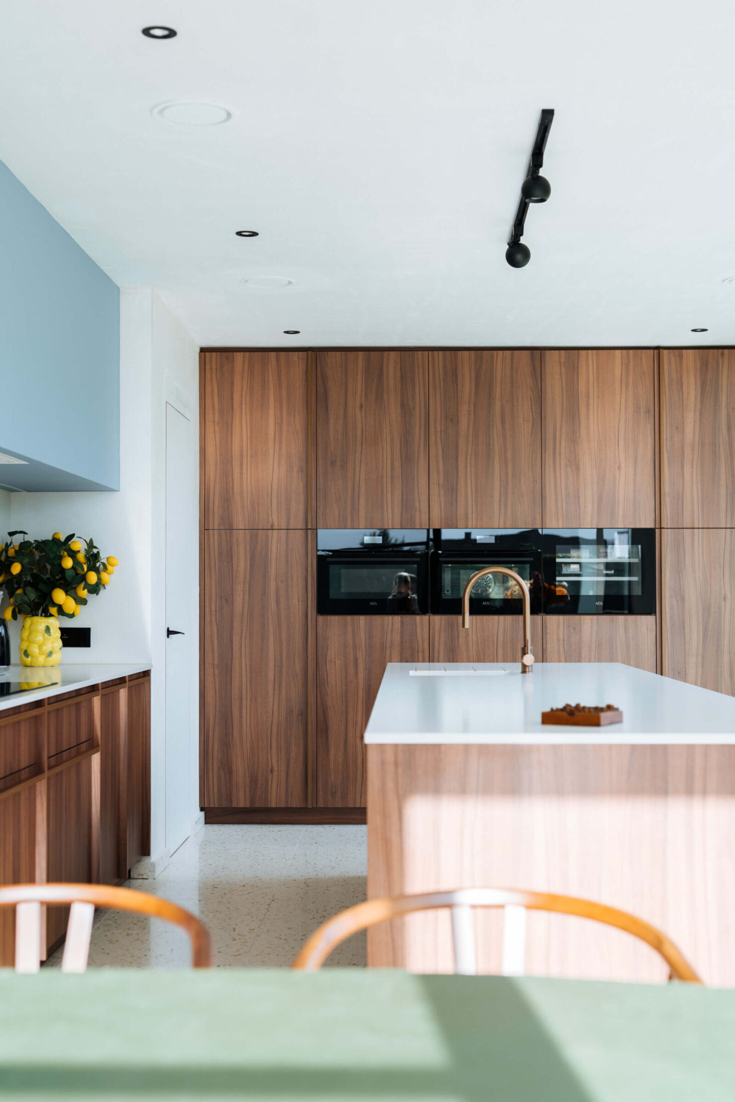 Scandinavische keuken met notelaar hoge kasten, ovens en houten eiland in Ardooie, Kaster Keukens