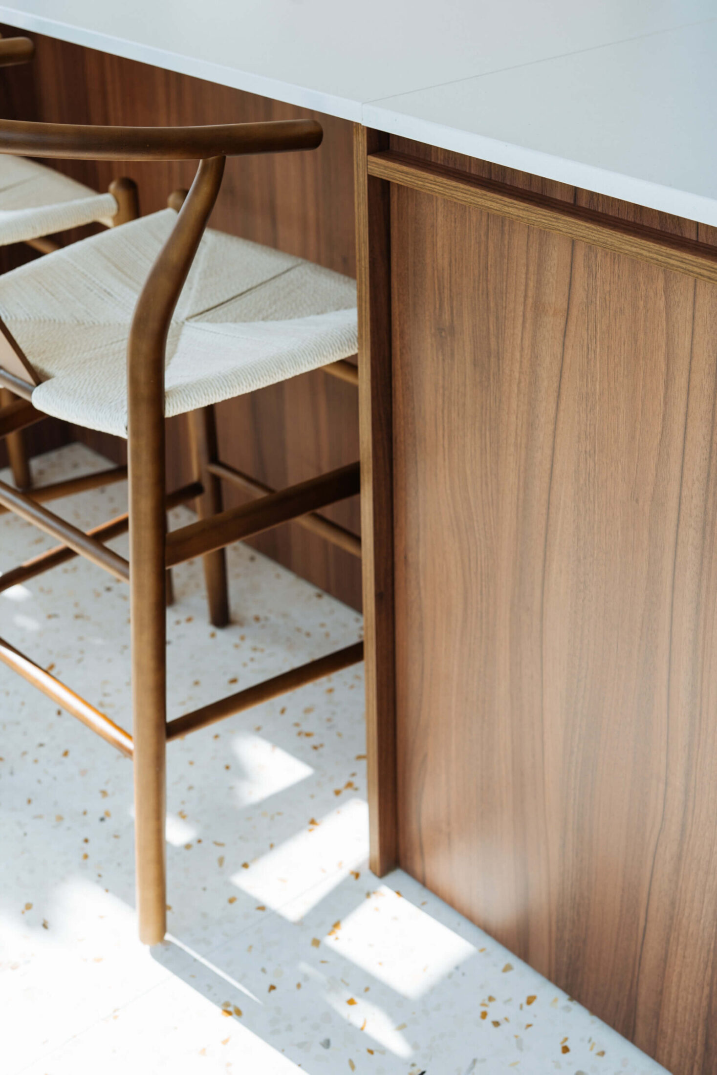 Detail van een scandinavische keuken met notelaar eiland en terrazzovloer in Ardooie, Kaster Keukens