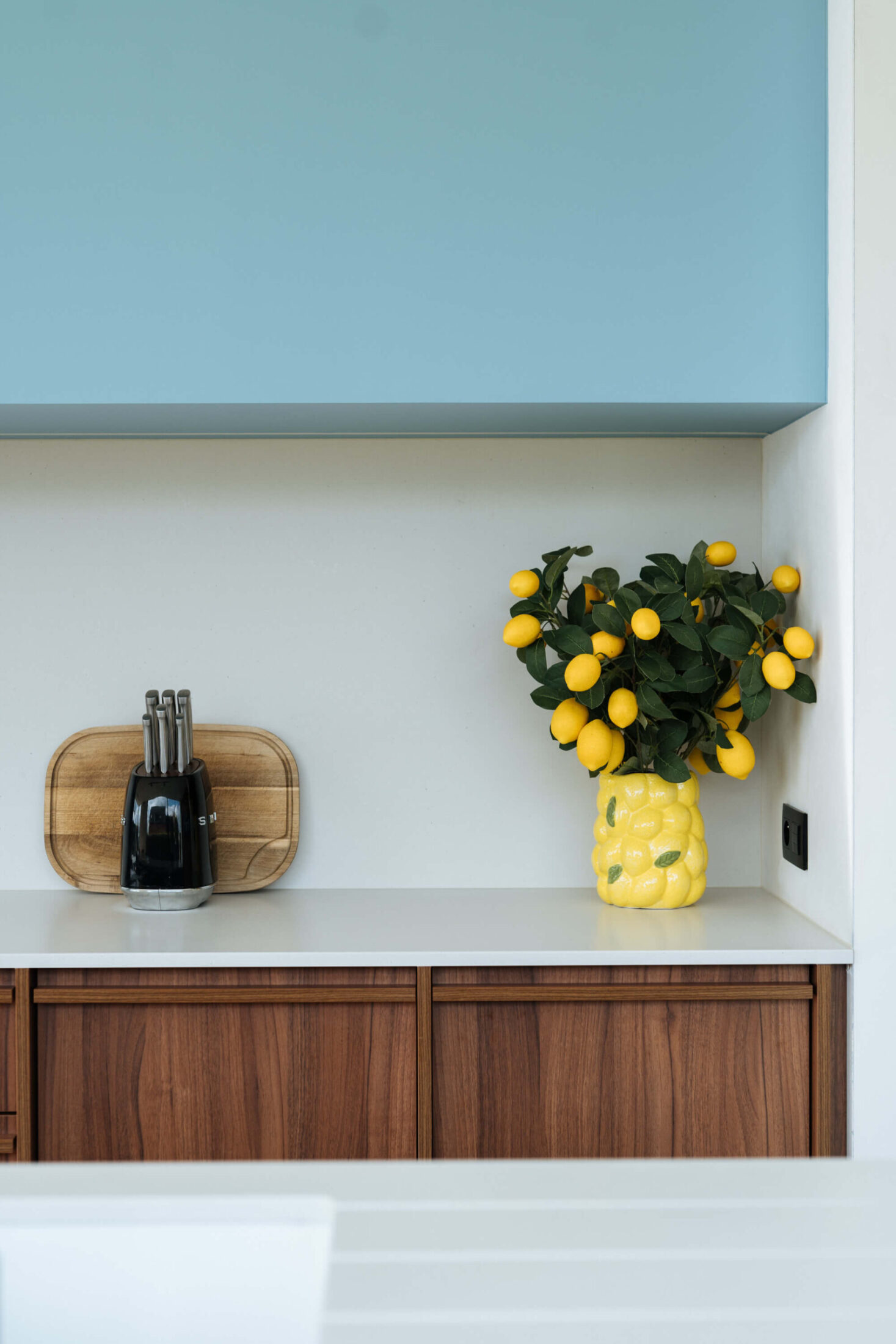 Detail van een scandinavische keuken met lichtblauwe bovenkast en notelaar lades in Ardooie, Kaster Keukens