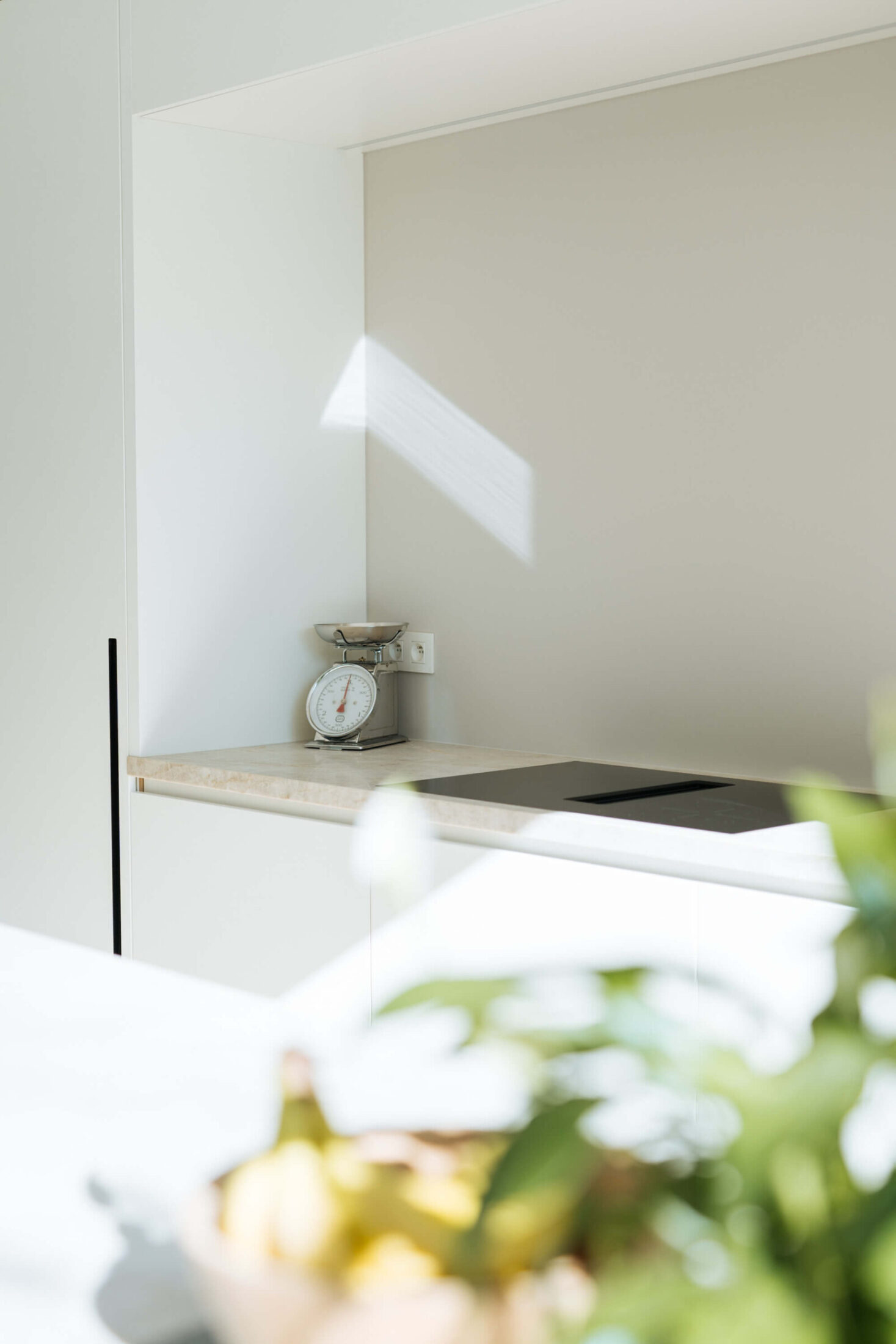 Detail van een scandinavische keuken met witte nis en kookplaat in Brugge, Kaster Keukens