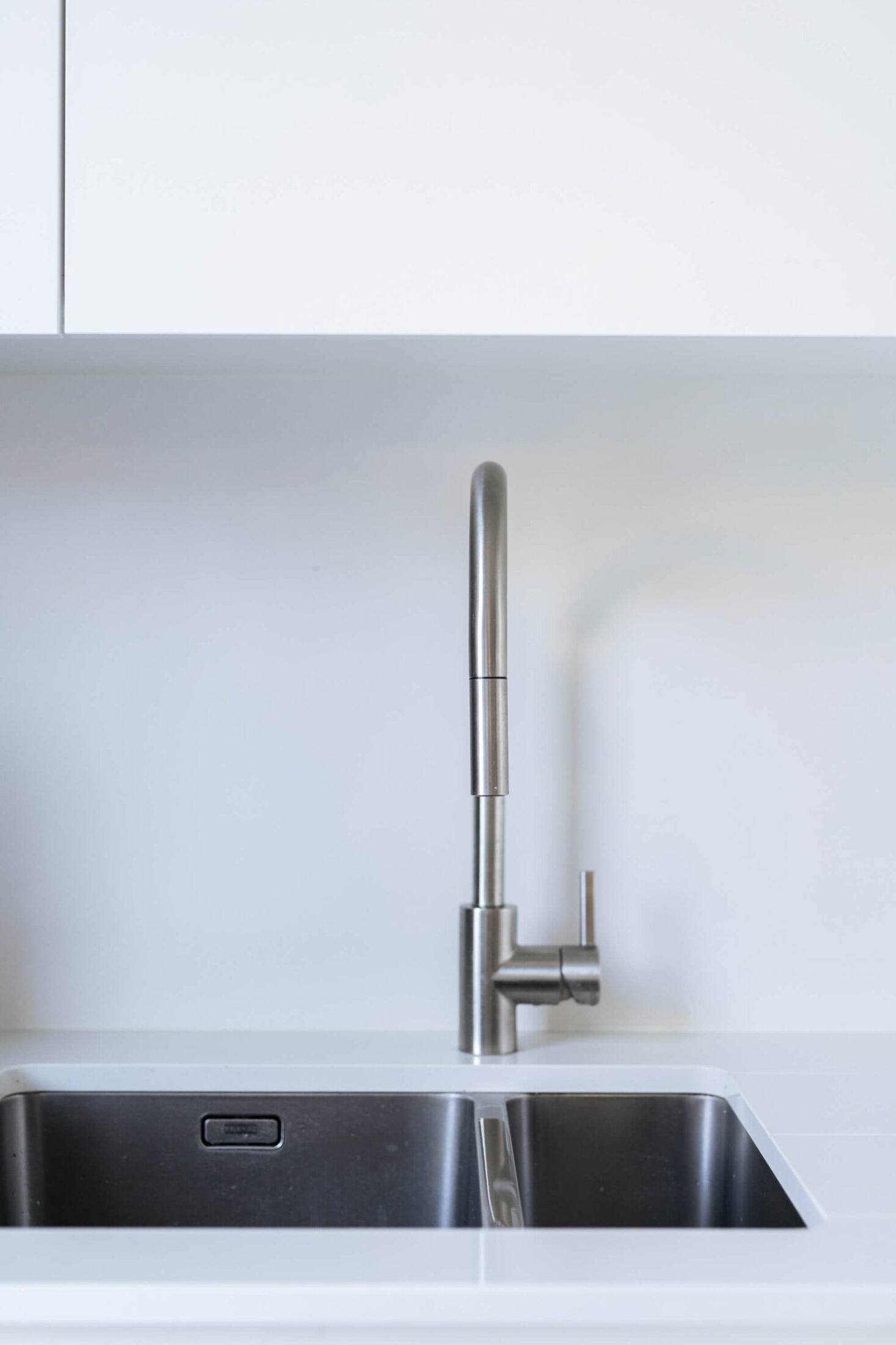 Detail van een Scandinavische keuken met inox spoelbak en kraan in Brugge, Kaster Keukens