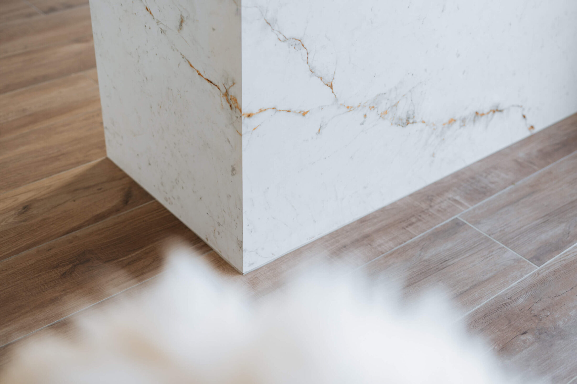 Detail van een Scandinavische keuken met marmerlook eiland op een houten vloer in Herzele, Kaster Keukens
