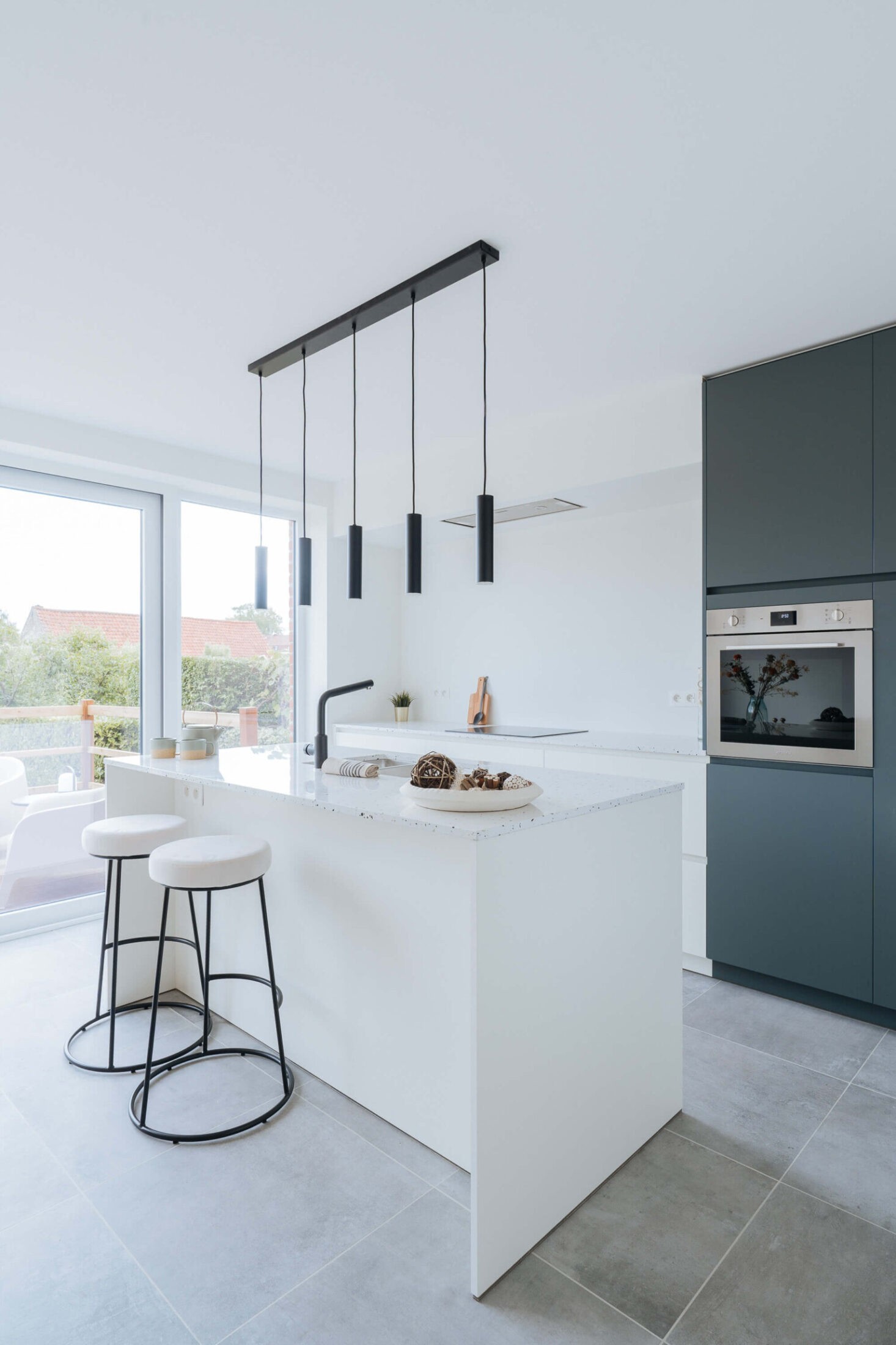 Scandinavische keuken met wit eiland, barkrukken en donkergroene kastenwand in Kortrijk, Kaster Keukens