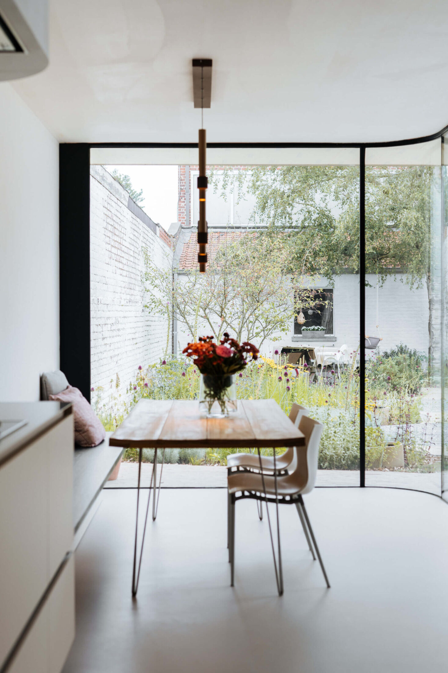 Scandinavische keuken met houten eettafel voor een grote raampartij in Lauwe, Kaster Keukens
