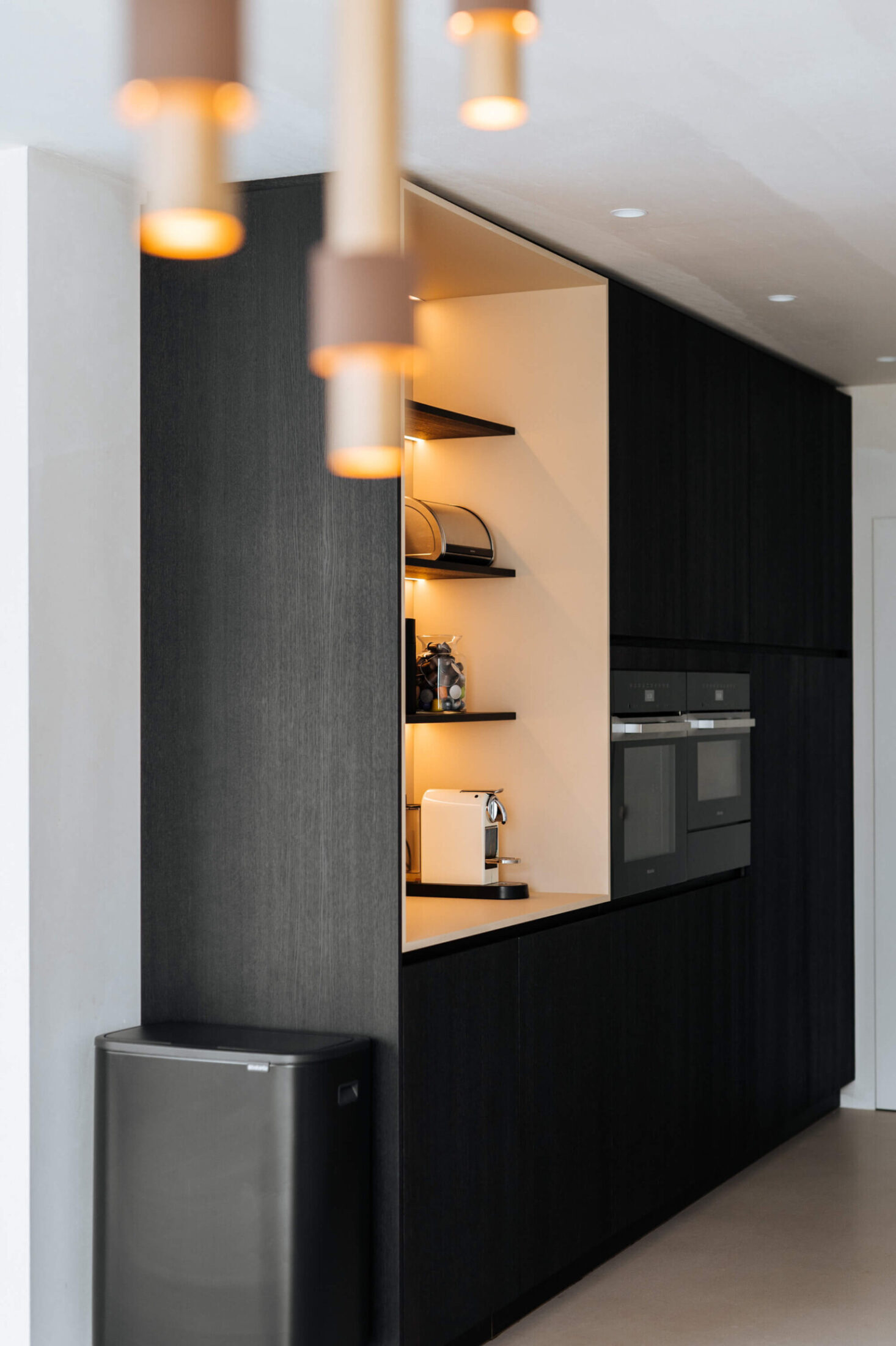 Scandinavische keuken met zwarte hoge kasten en verlichte nis in Lauwe, Kaster Keukens