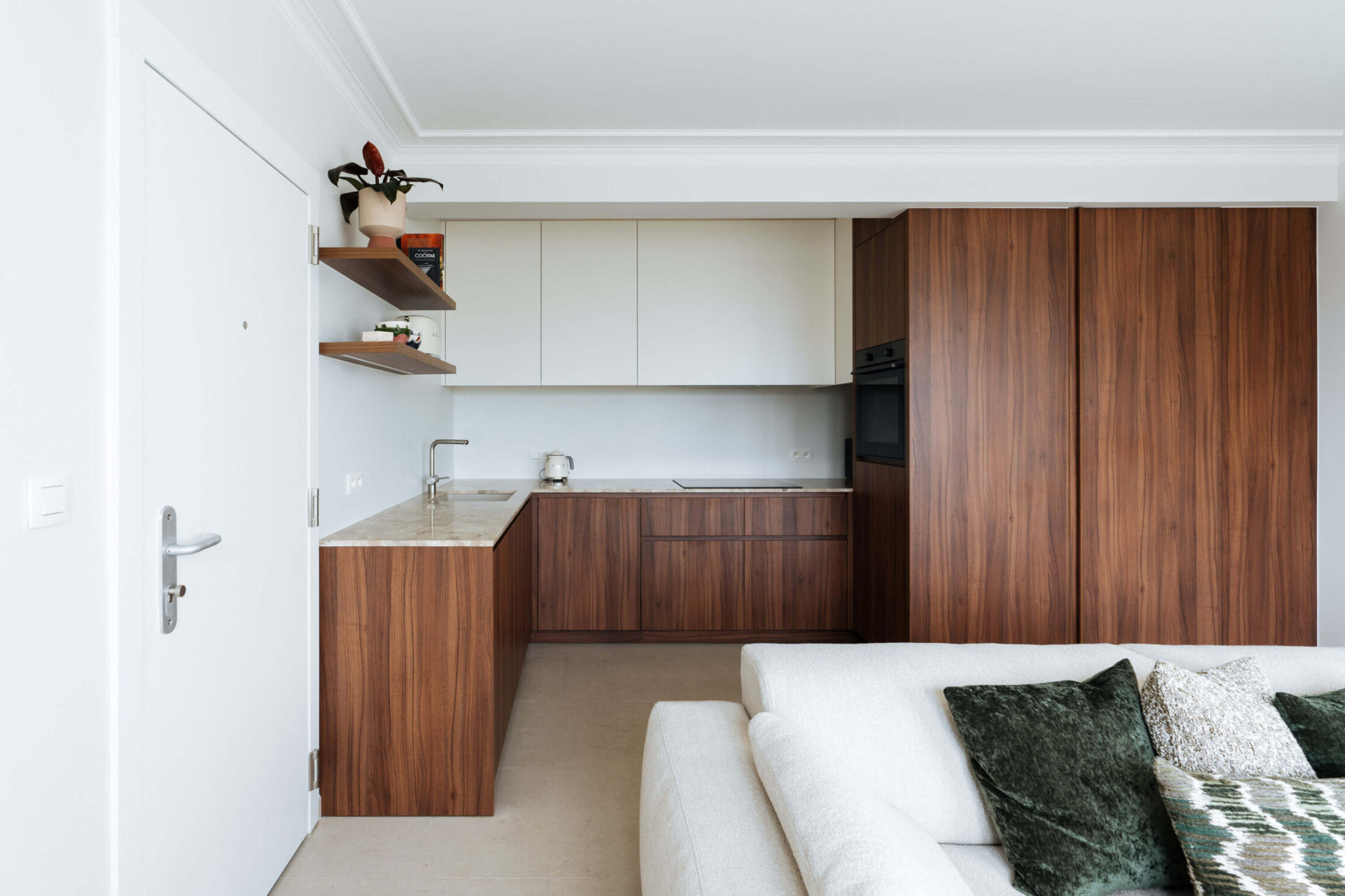 Scandinavische keuken met notelaren onderkasten, witte bovenkasten en houten wandrek in Oostende, Kaster Keukens