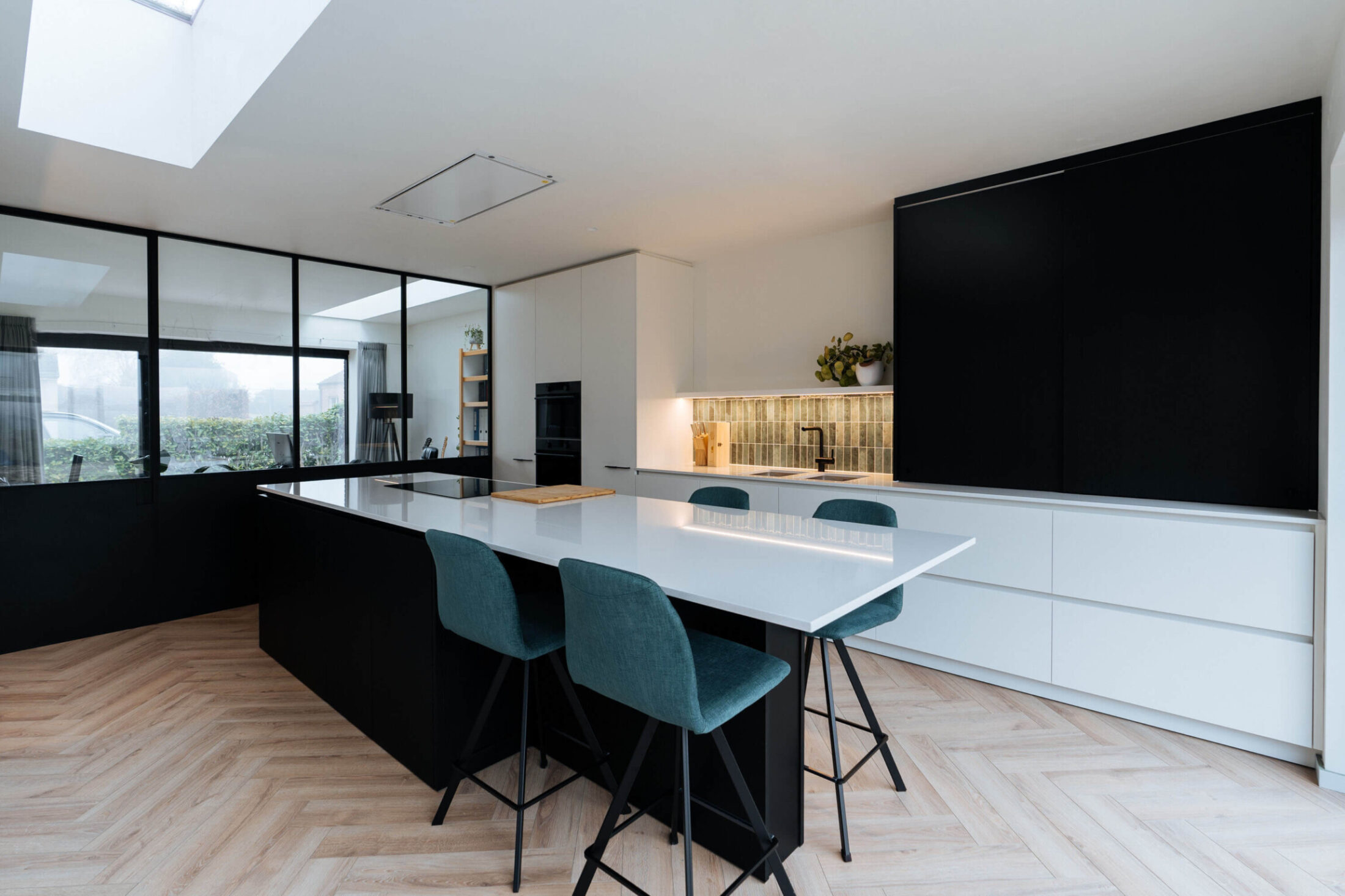 Scandinavische keuken met zwart eiland, wit werkblad en blauwgroene barkrukken in Roeselare, Kaster Keukens