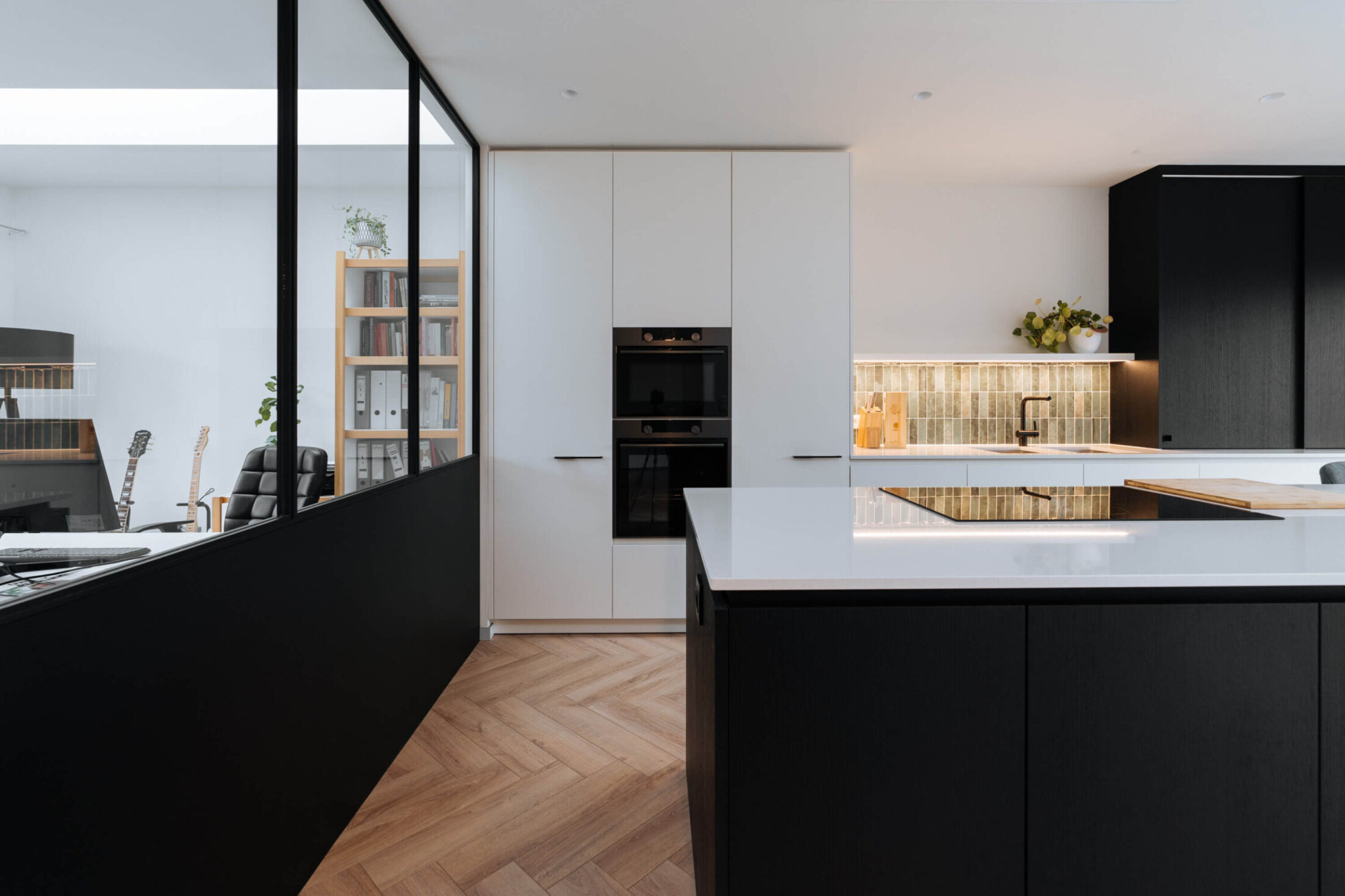 Scandinavische keuken met zwart kookeiland, witte hoge kasten en glazen wand in Roeselare, Kaster Keukens
