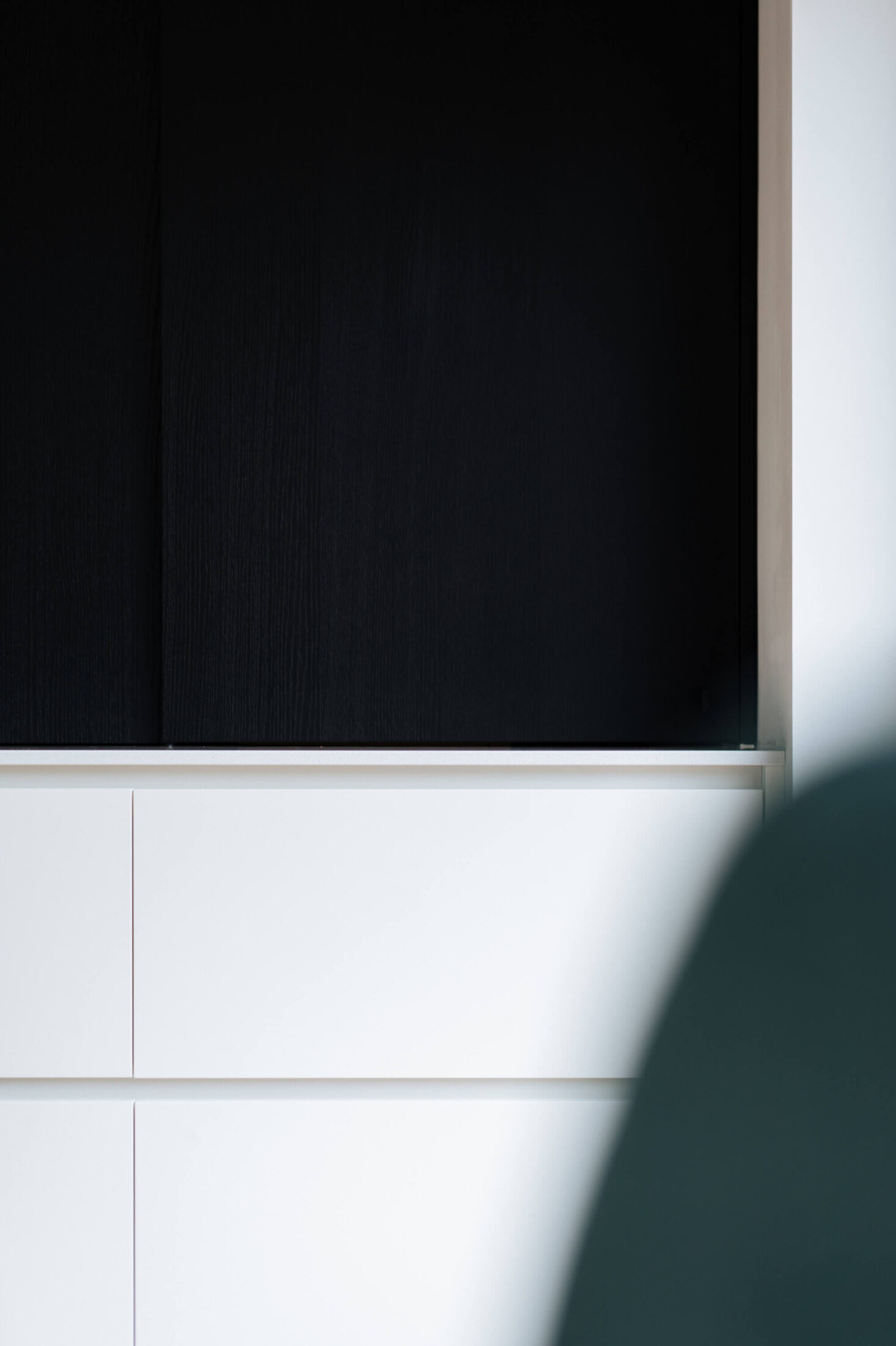 Detail van een Scandinavische keuken met zwarte bovenkast en witte fronten in Roeselare, Kaster Keukens