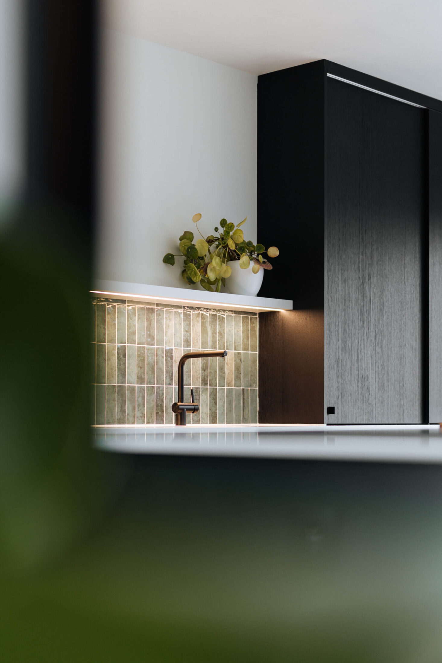 Scandinavische keuken met groene wandtegels en zwarte hoge kast in Roeselare, Kaster Keukens