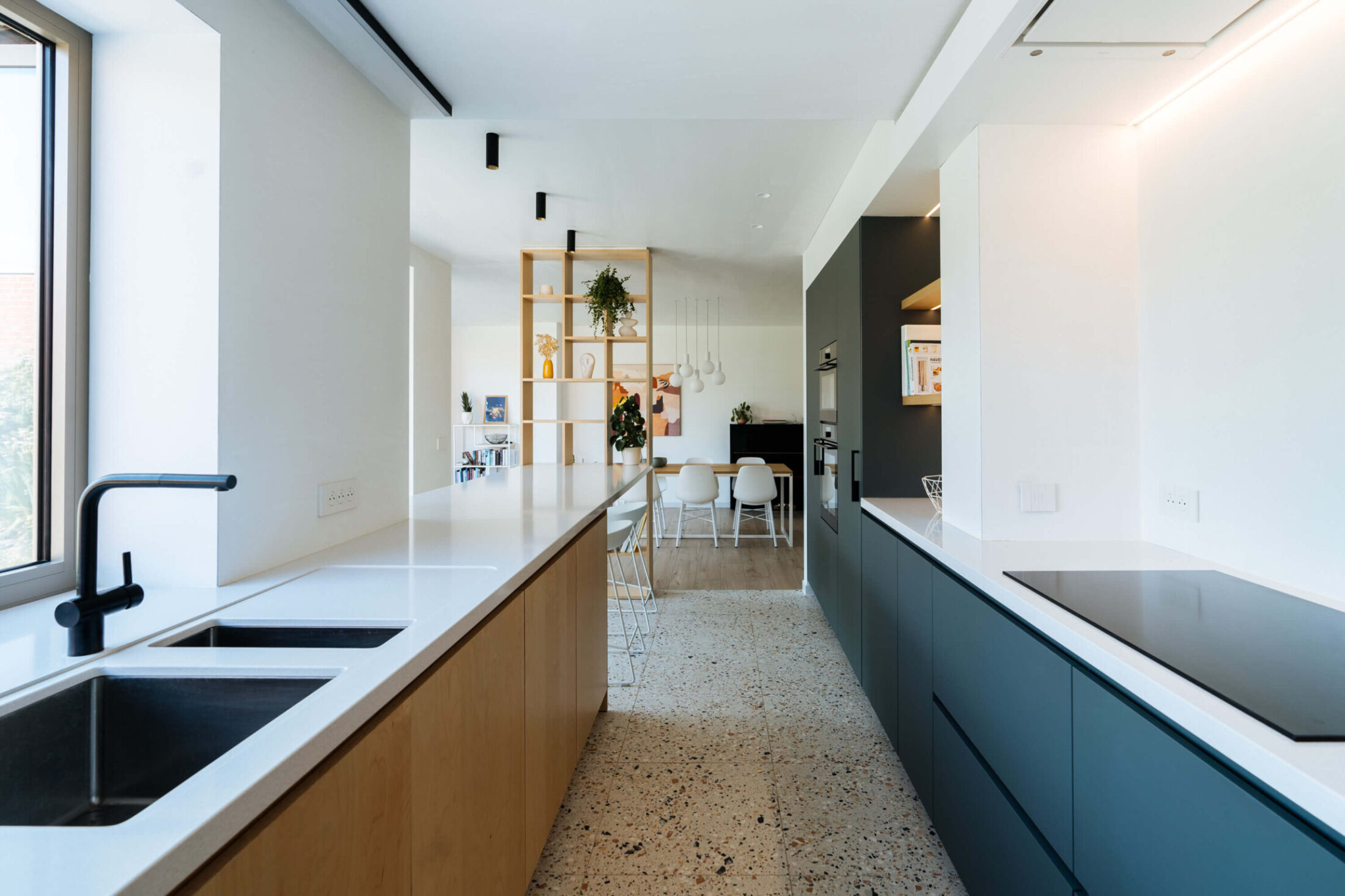 Scandinavische keuken met eiken en donkerblauwe fronten, wit werkblad en terrazzovloer in Roeselare, Kaster Keukens