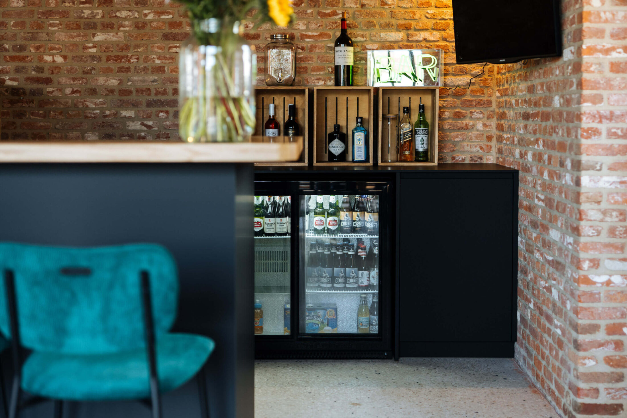 Detail van een bar op maat met glazen drankkoelkasten en flessenrekjes in Beveren, Kaster Keukens