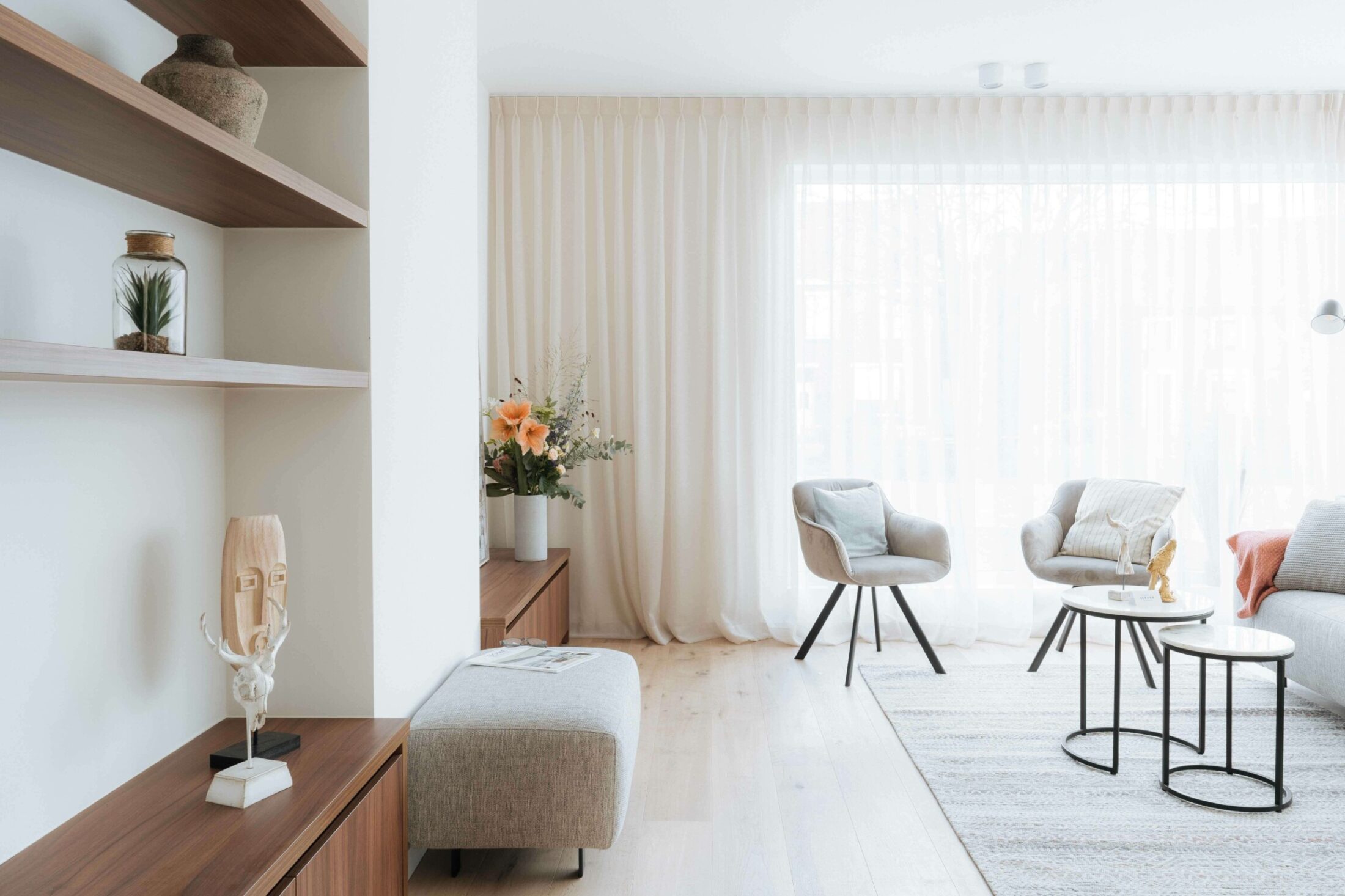 Kastenwand op maat in notelaar met open rekken en lage kast in een lichte living in Kortrijk, Kaster Keukens