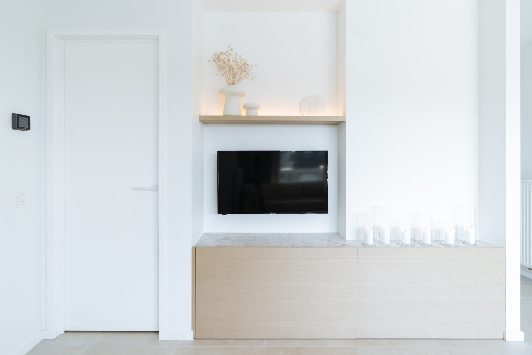 Tv-meubel op maat met eiken onderkast, witte nis en wandplank met ledverlichting in Middelkerke, Kaster Keukens