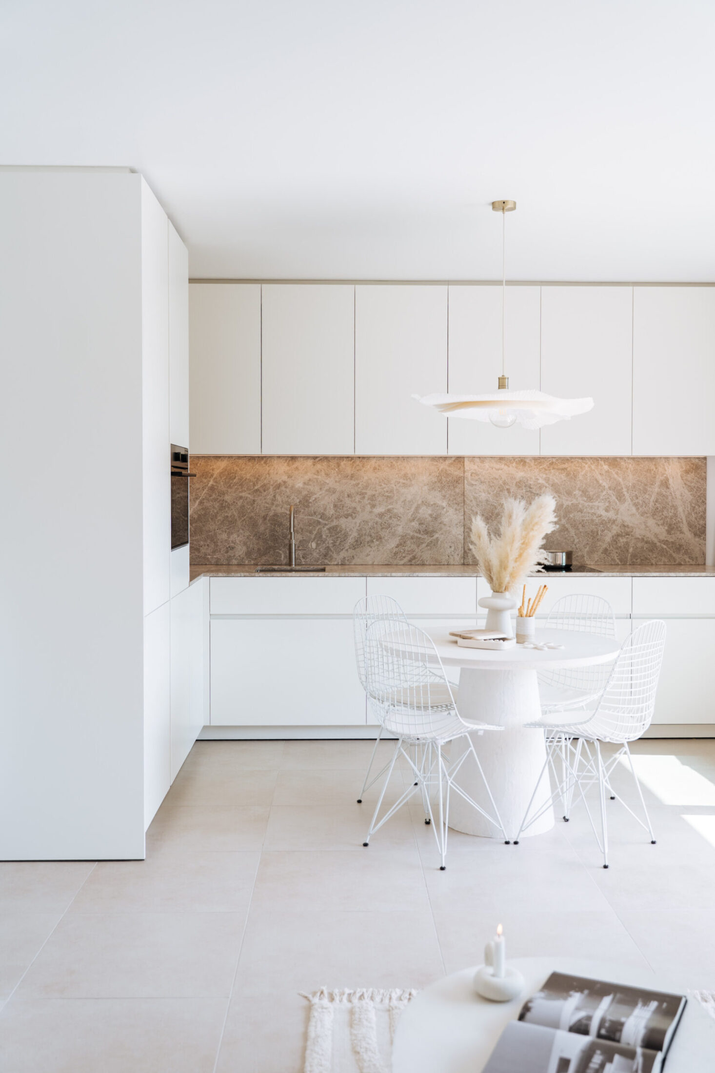 Moderne keuken met witte hoge kasten en beige marmerlook achterwand in Middelkerke, Kaster Keukens