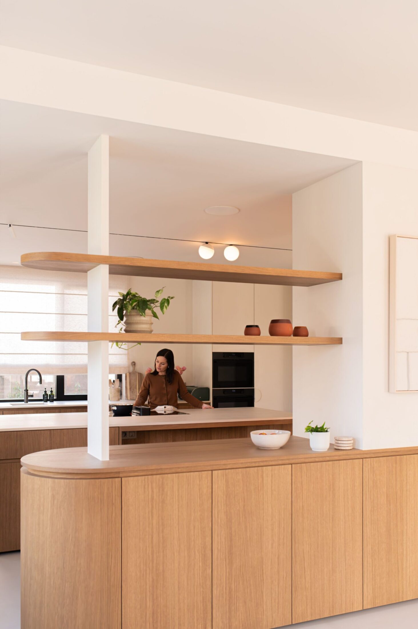 Scandinavische keuken met afgerond eiken eiland en zwevende houten wandplanken in Roeselare, Kaster Keukens