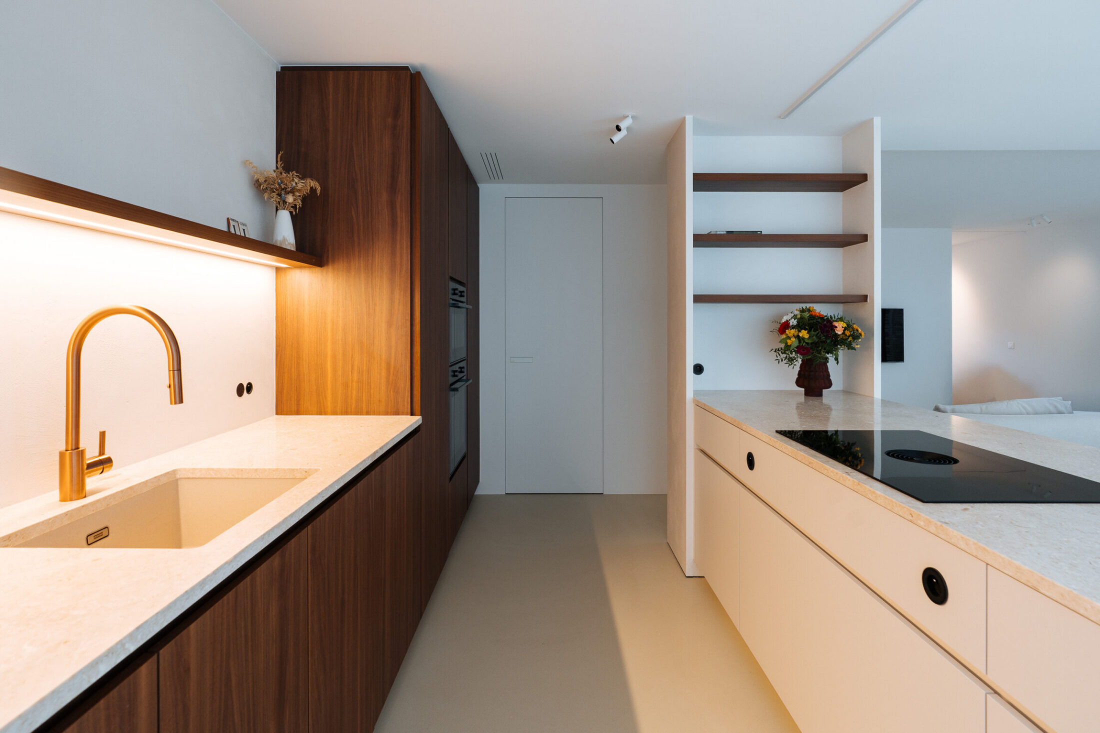 Moderne keuken met notelaar fronten, goudkleurige kraan en wit eiland met kookplaat in Zwevegem, Kaster Keukens
