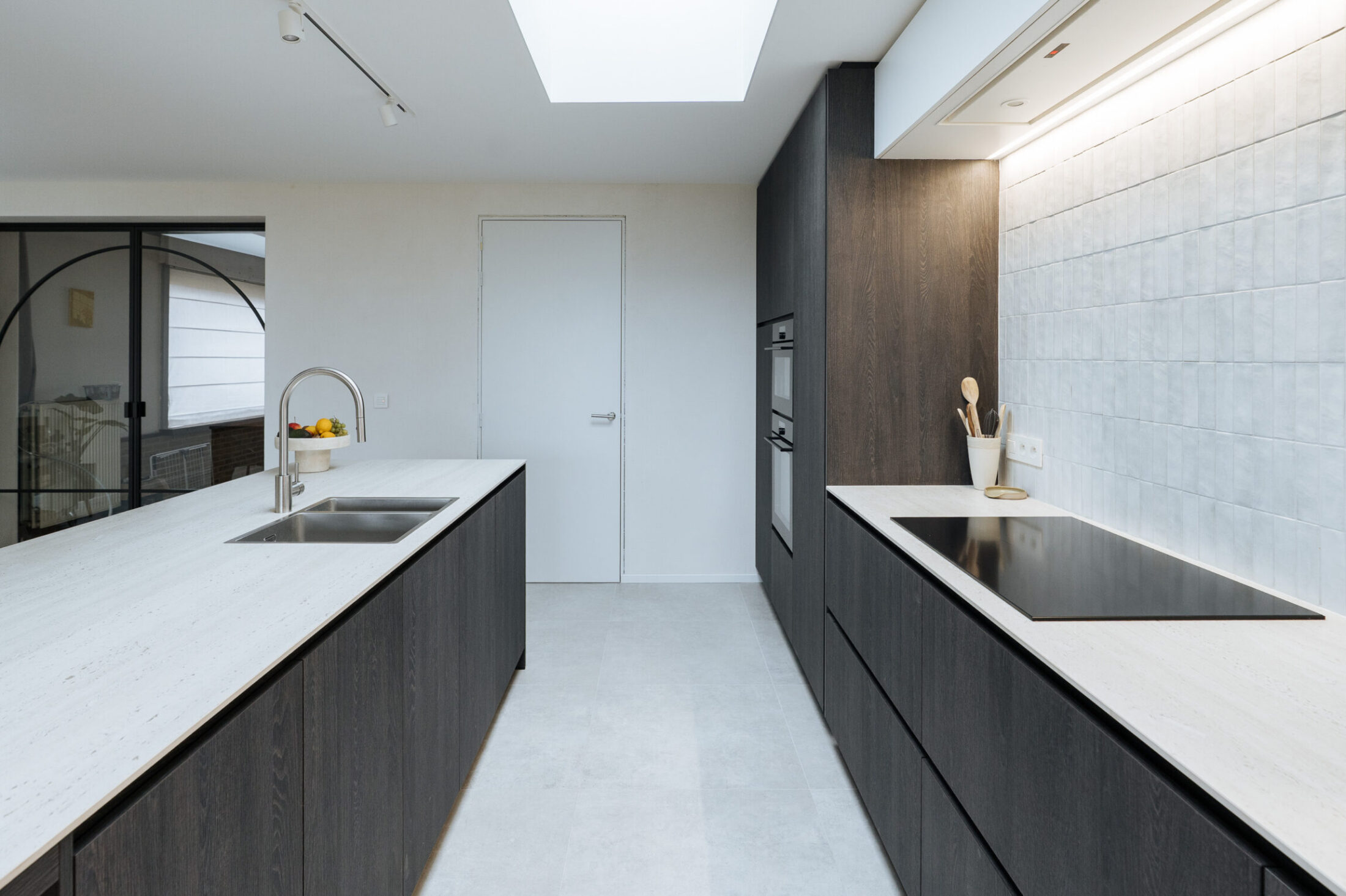 Moderne keuken met donkere houten fronten, wit werkblad, lichtgrijze wandtegels en lichtkoepel in Ardooie, Kaster Keukens