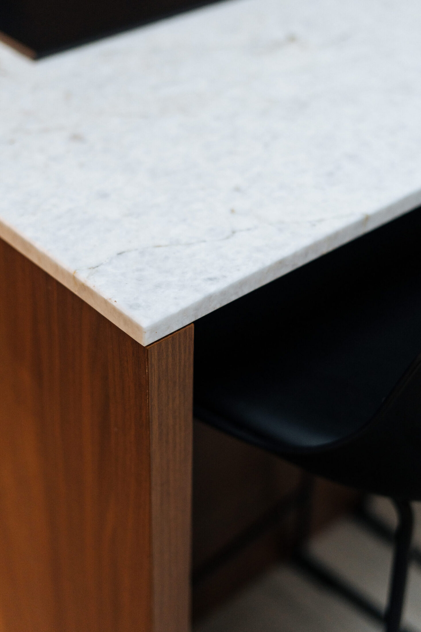 Detail van een moderne keuken met wit marmerlook werkblad op een notelaar eiland in Hooglede, Kaster Keukens