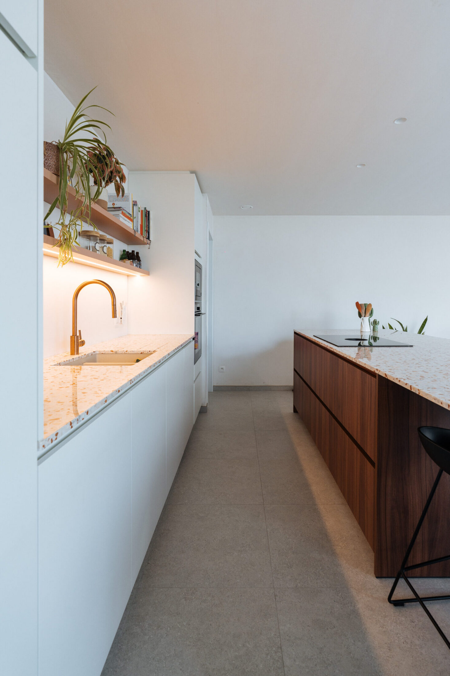 Moderne keuken met witte fronten, terrazzo werkblad en notelaar eiland in Merelbeke, Kaster Keukens