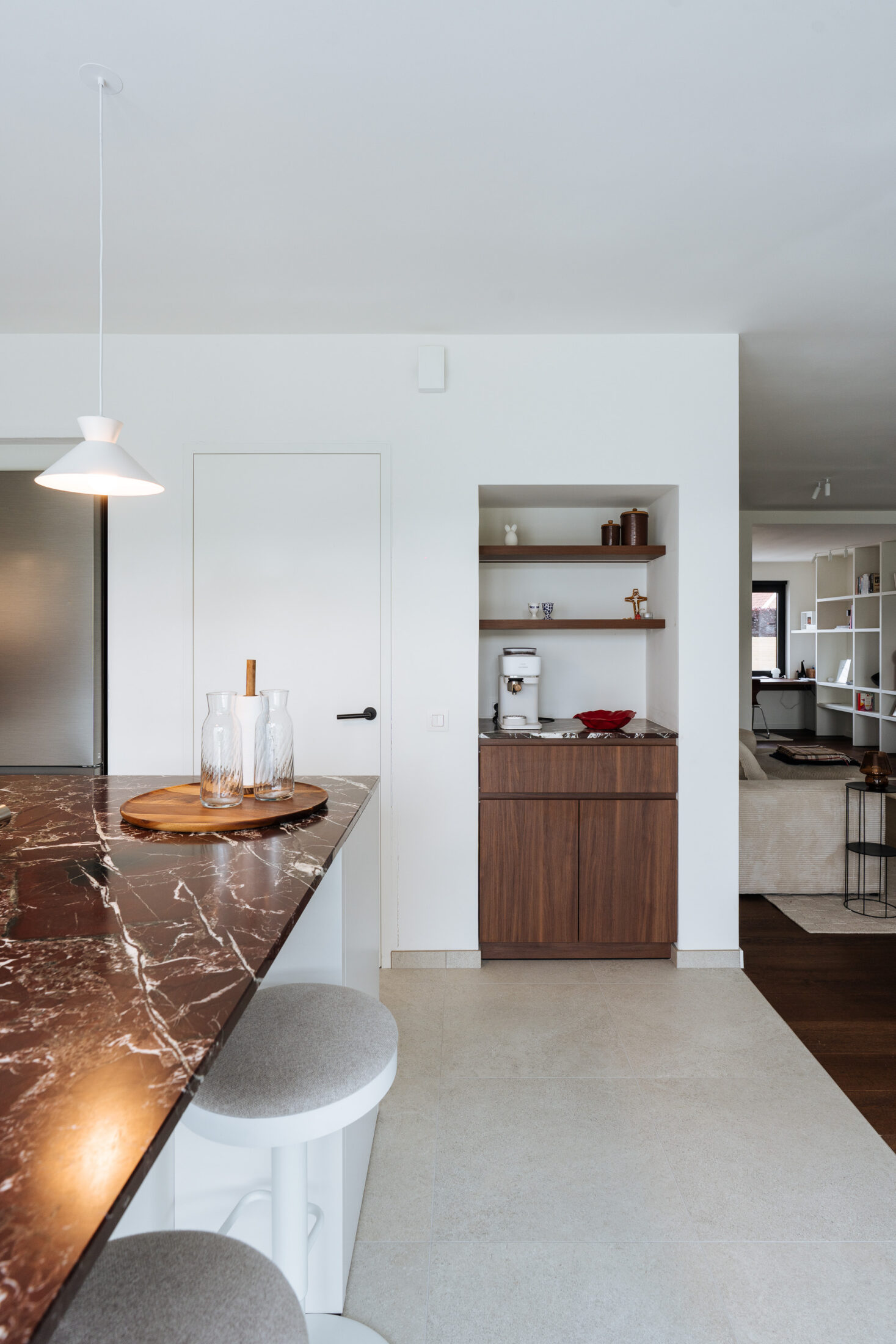 Moderne keuken met eiland in bordeaux marmer en zicht op een houten kastnis in Waregem, Kaster Keukens