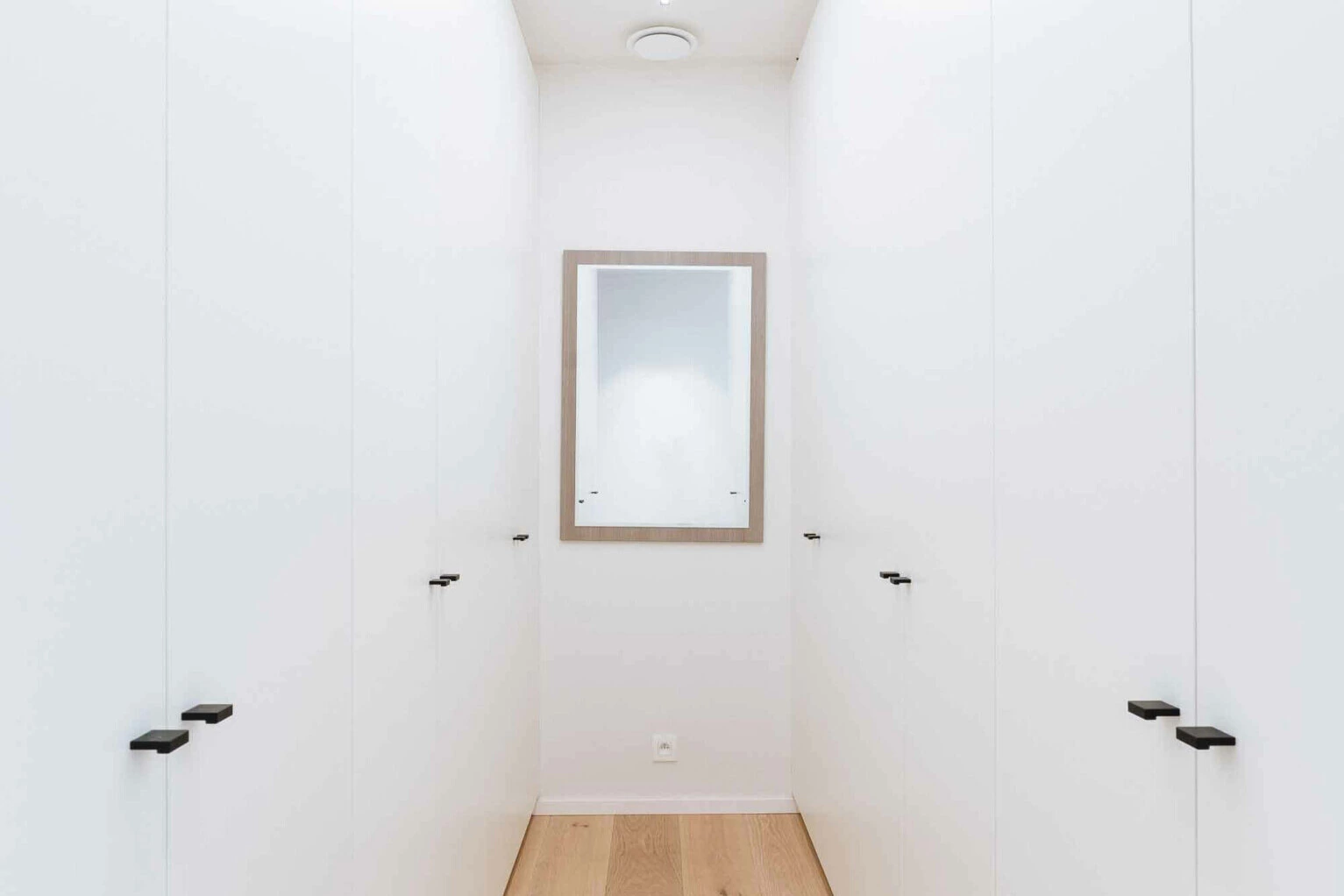 Ingebouwde kastenwand met greeploze deuren als dressing op maat