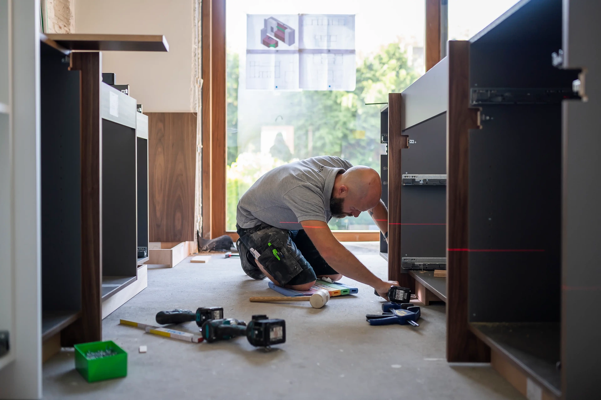 Plaatser van Kaster Keukens monteert de kasten van een nieuwe keuken tijdens een keukenrenovatie