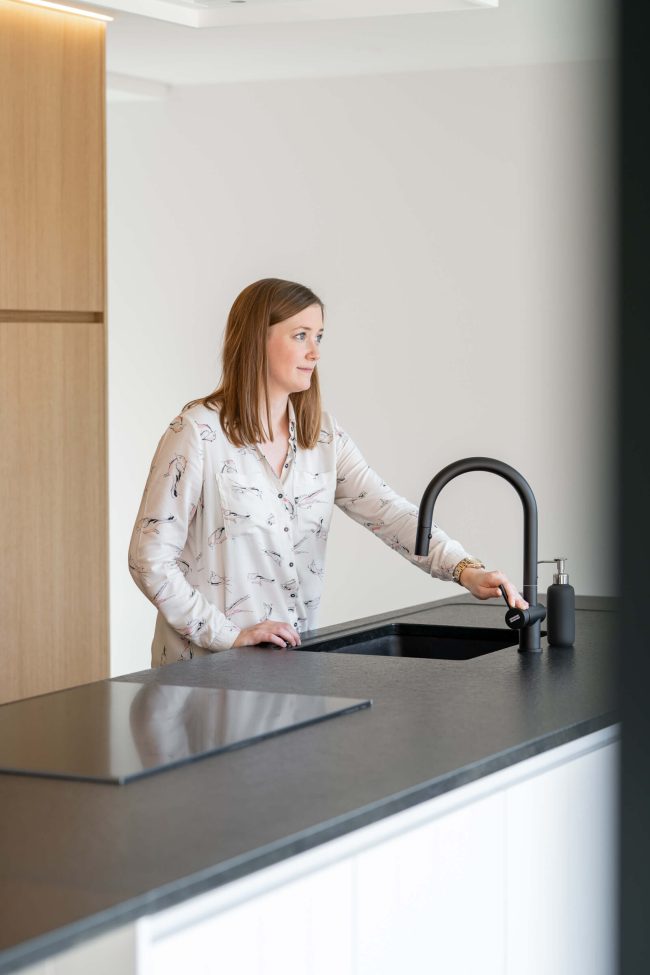 Landelijke keuken met donker werkblad, zwarte kraan en eiken kastenwand in Rollegem-Kapelle, Kaster Keukens