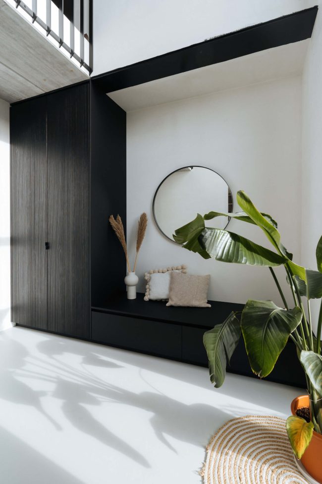 Kastenwand op maat in donker hout met ronde spiegel en zitbank in Kortrijk, Kaster Keukens