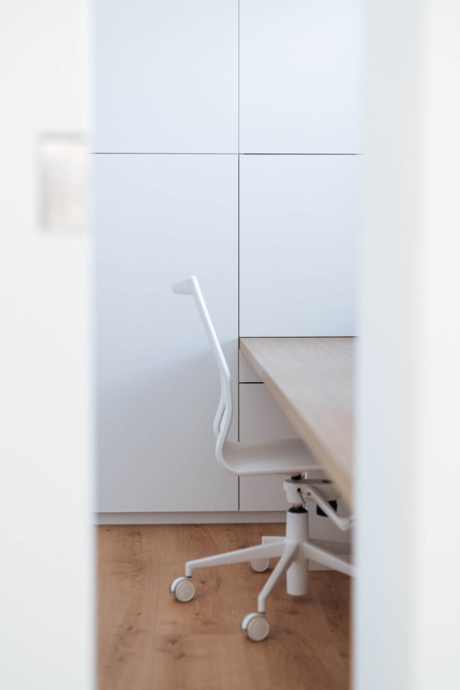 Bureau op maat met houten blad in een nis tussen witte kasten in Roeselare, Kaster Keukens