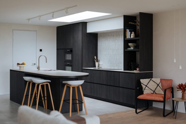 Moderne keuken met donker kookeiland, houten barkrukken en zwarte hoge kasten met open rek in Ardooie, Kaster Keukens